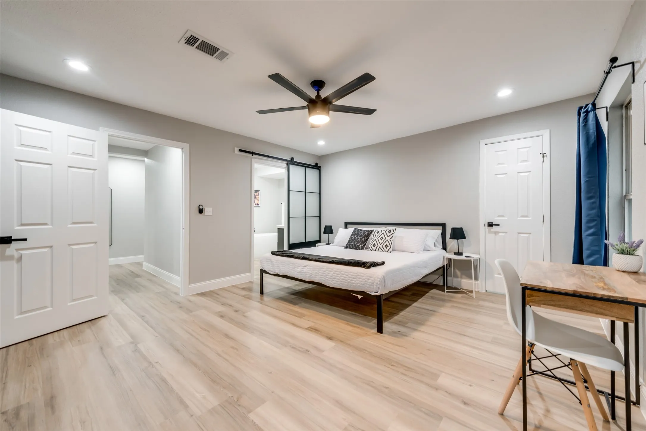 Bedroom featuring a barn door, light wood-style floors, recessed lighting, and a ceiling fan