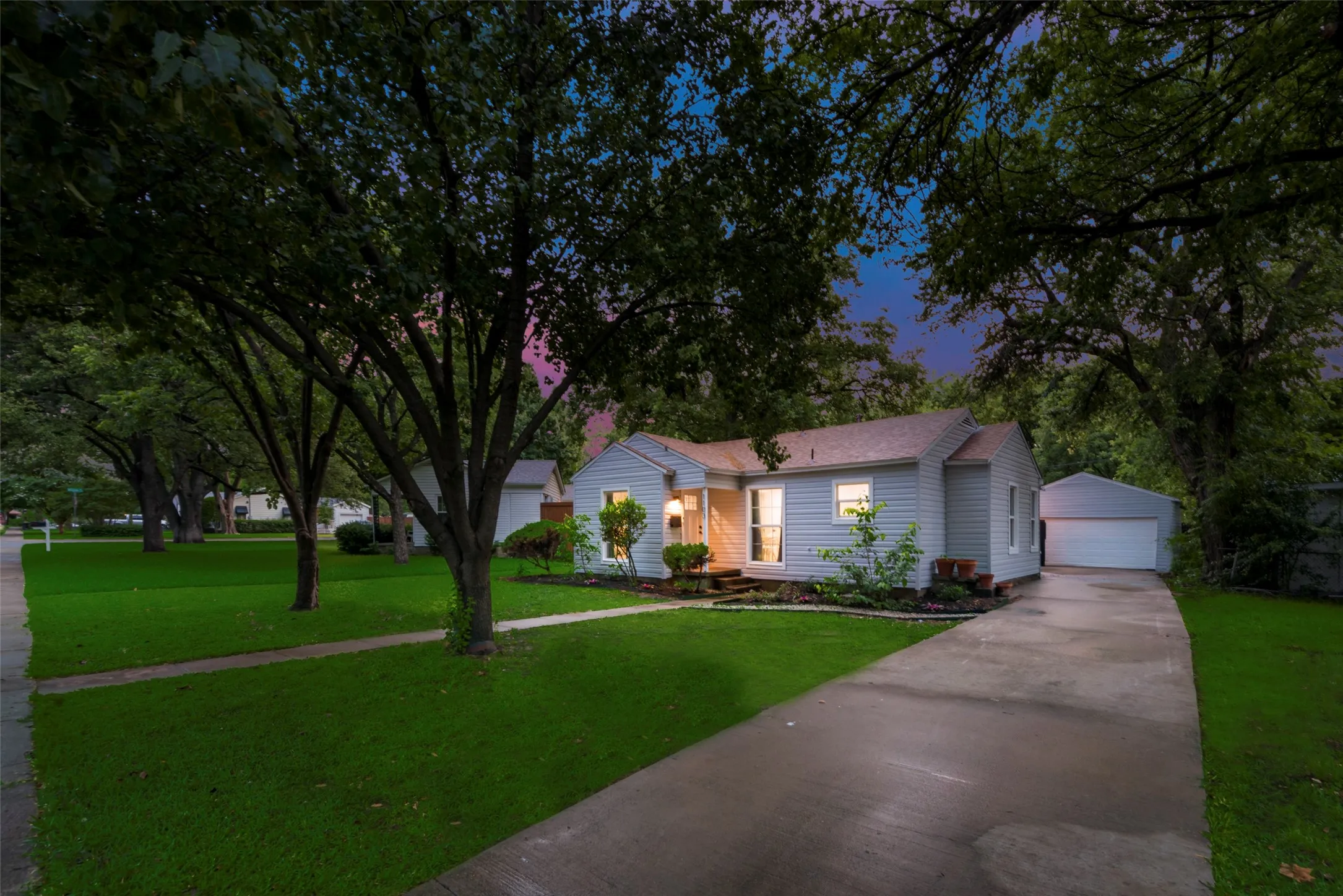 Single story home featuring an outbuilding, a front lawn, and a garage