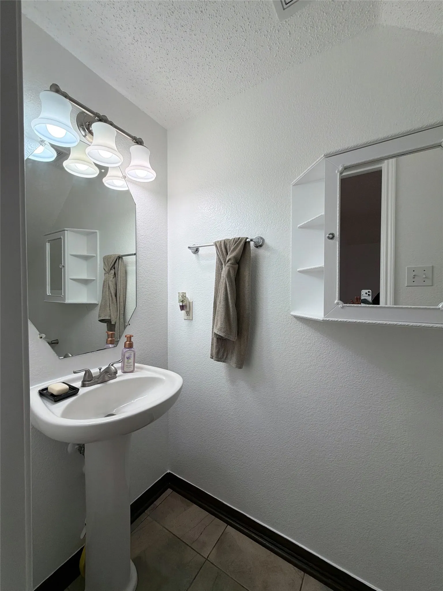 Half Bath with a textured ceiling and dark tile patterned floors