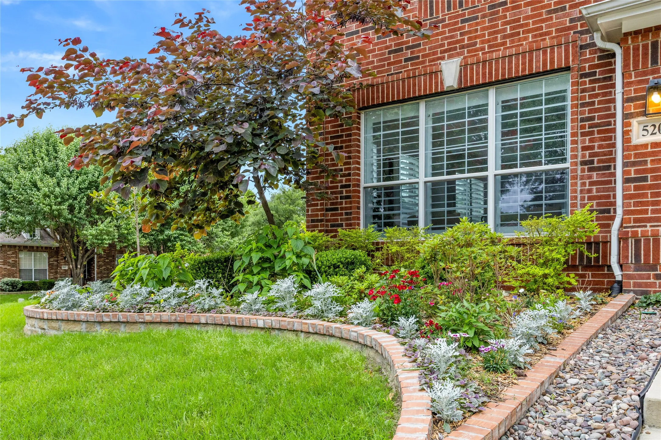 Owner put in thousands of dollars in landscaping and hardscaping with stone borders/edging. All kinds of perennials, bushes and trees around property. It is absolutely beautiful.  This picture was early spring, now plants are much bigger and flourishing. Must see!