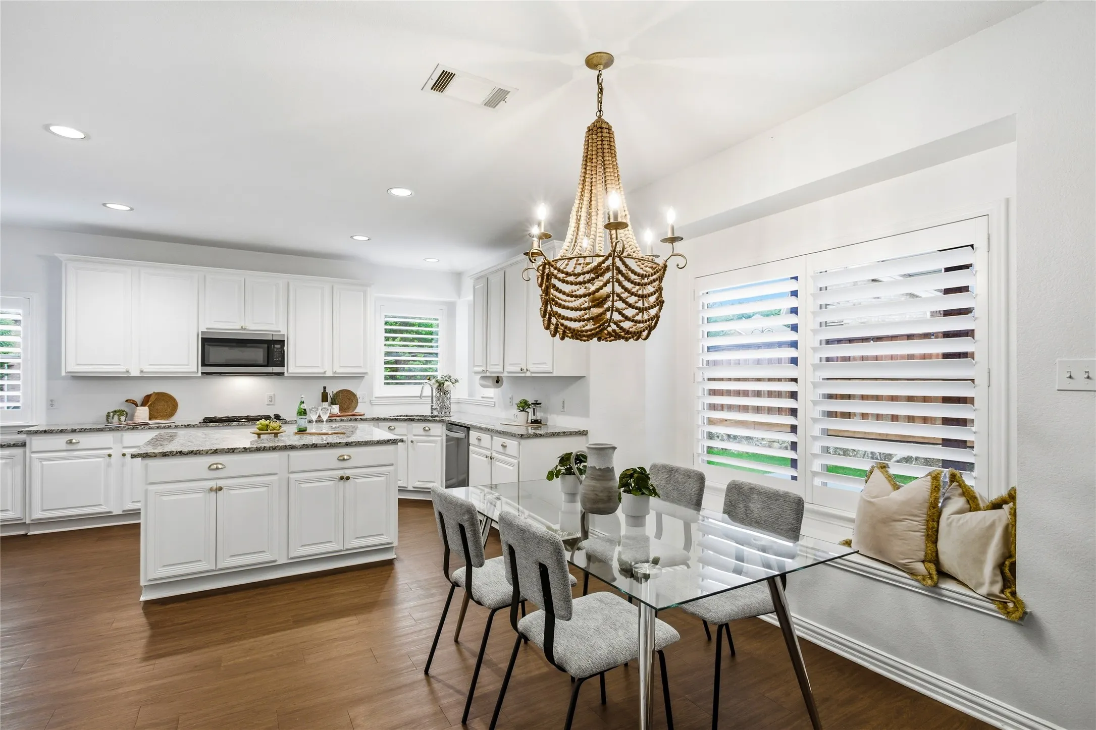 Sunny kitchen nook with window seat and beautiful beaded chandelier.