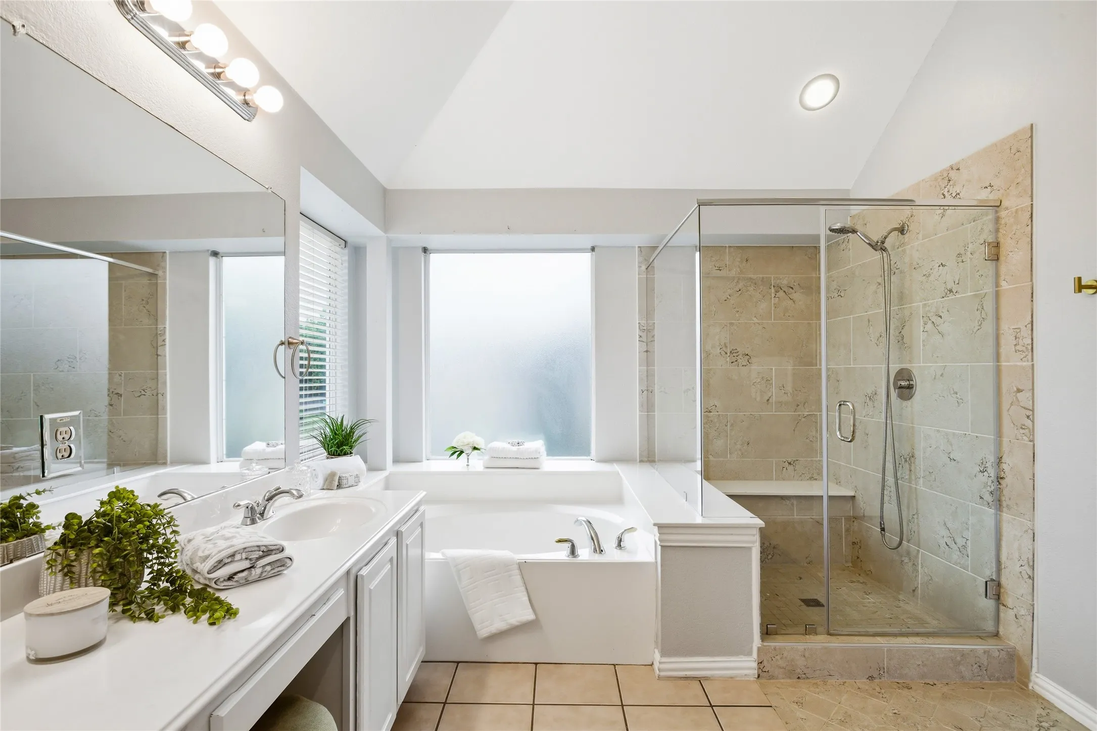 View of primary bath with garden tub, separate step in shower and  double sink vanity.