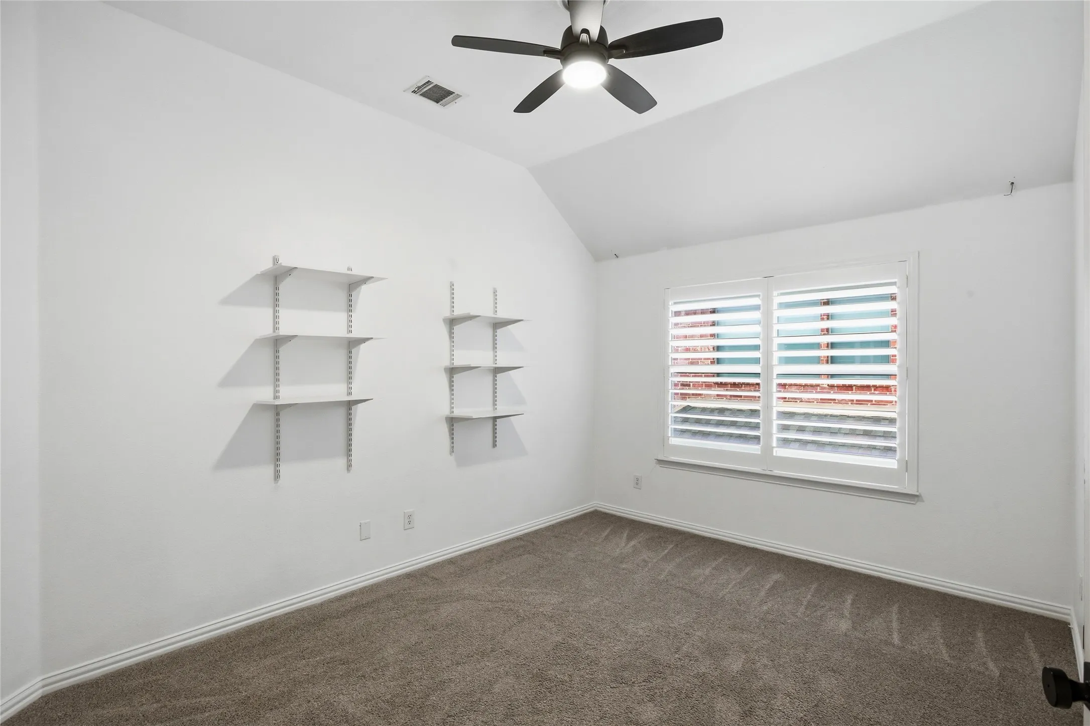 Another view of spare bedroom with wall shelves. Great size secondary bedrooms..