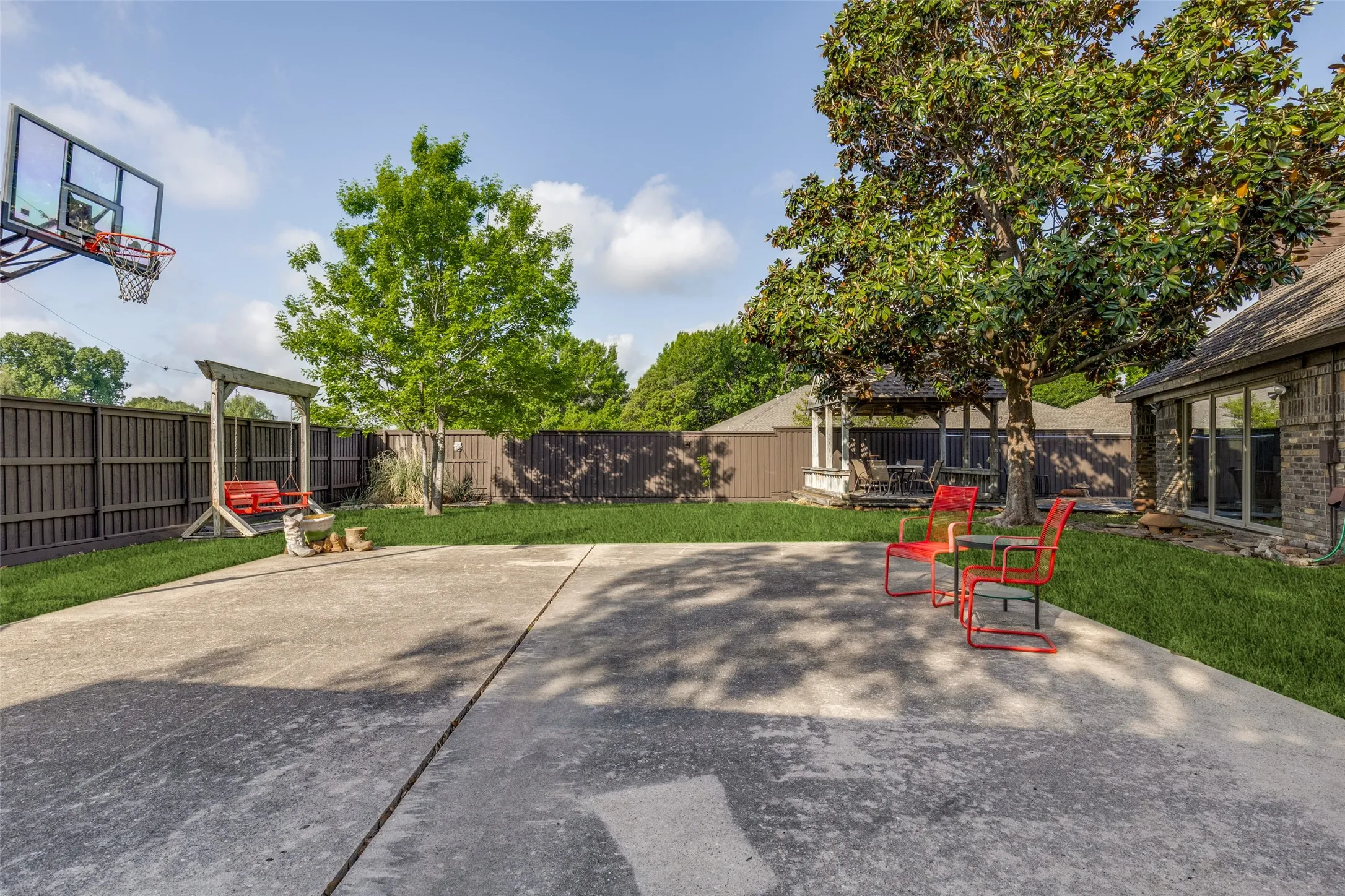 View of back yard with large area to play basketball and grassy area for kids and pets to run and play