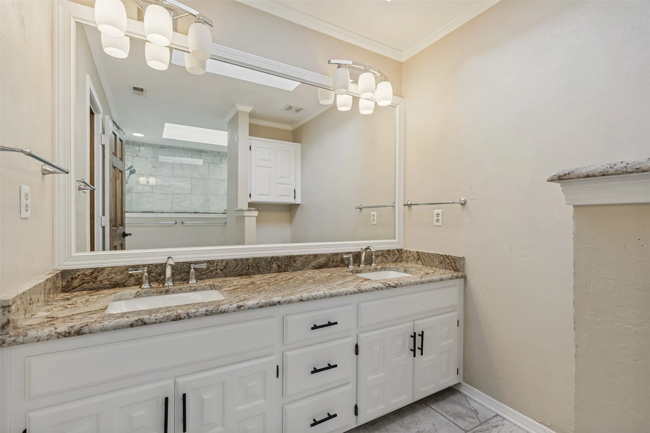 Primary Bathroom with Dual sinks and granite counter tops. Also has a large walk-in closet with custom shelving