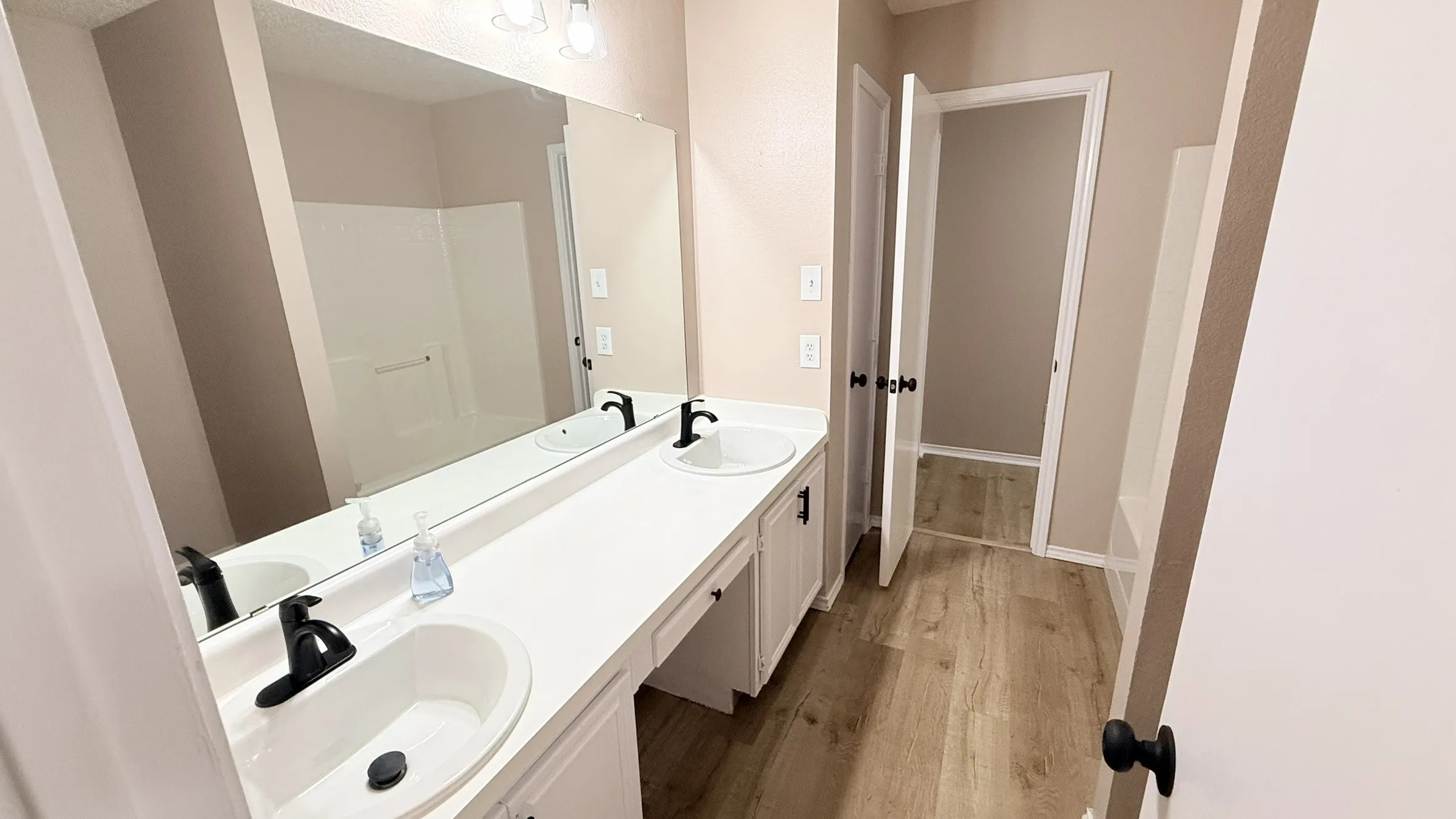 Full bathroom with double vanity and light wood finished floors