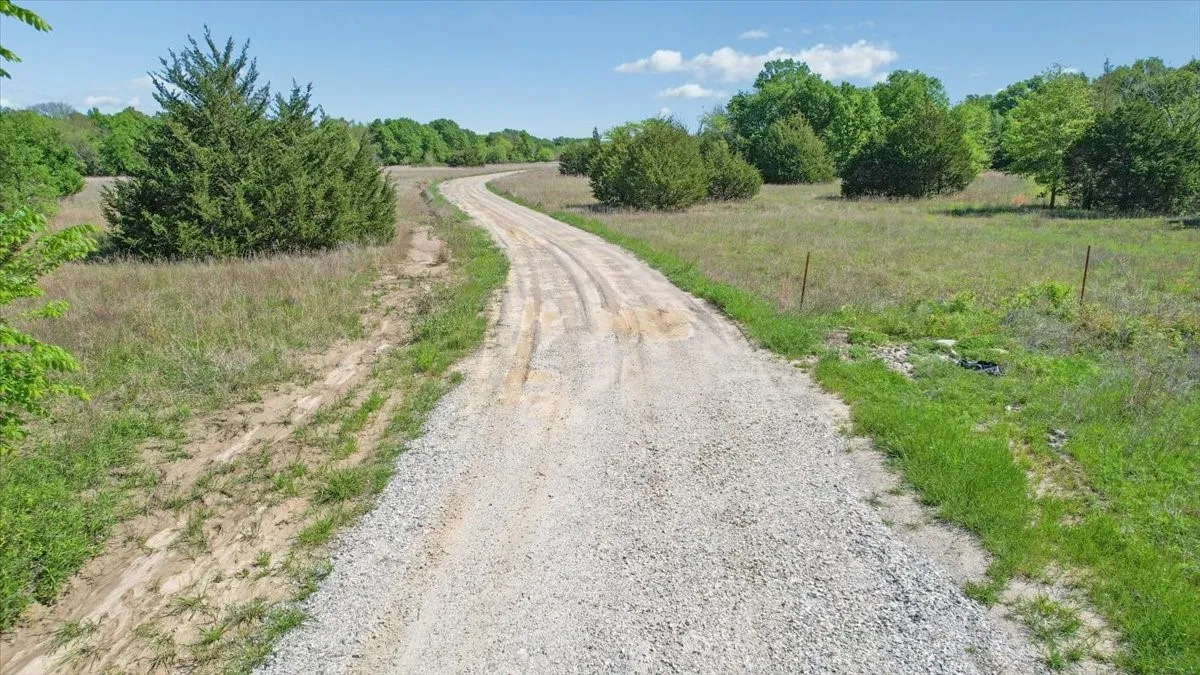 View of dirt / gravel road with a rural view