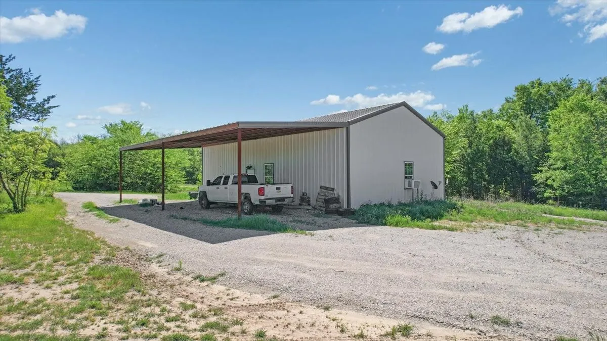 View of parking featuring a carport and driveway
