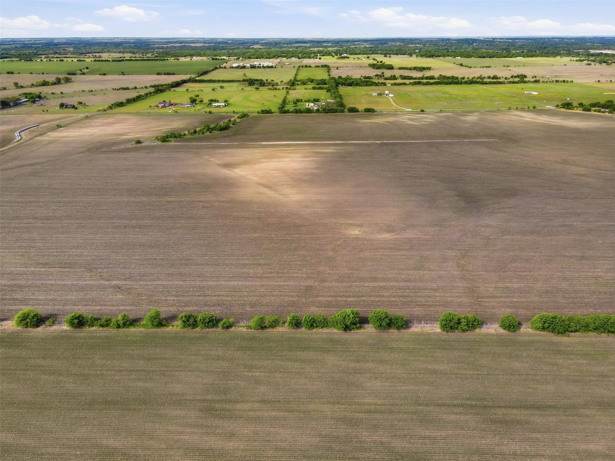 Aerial view of sparsely populated area with large plots for crops