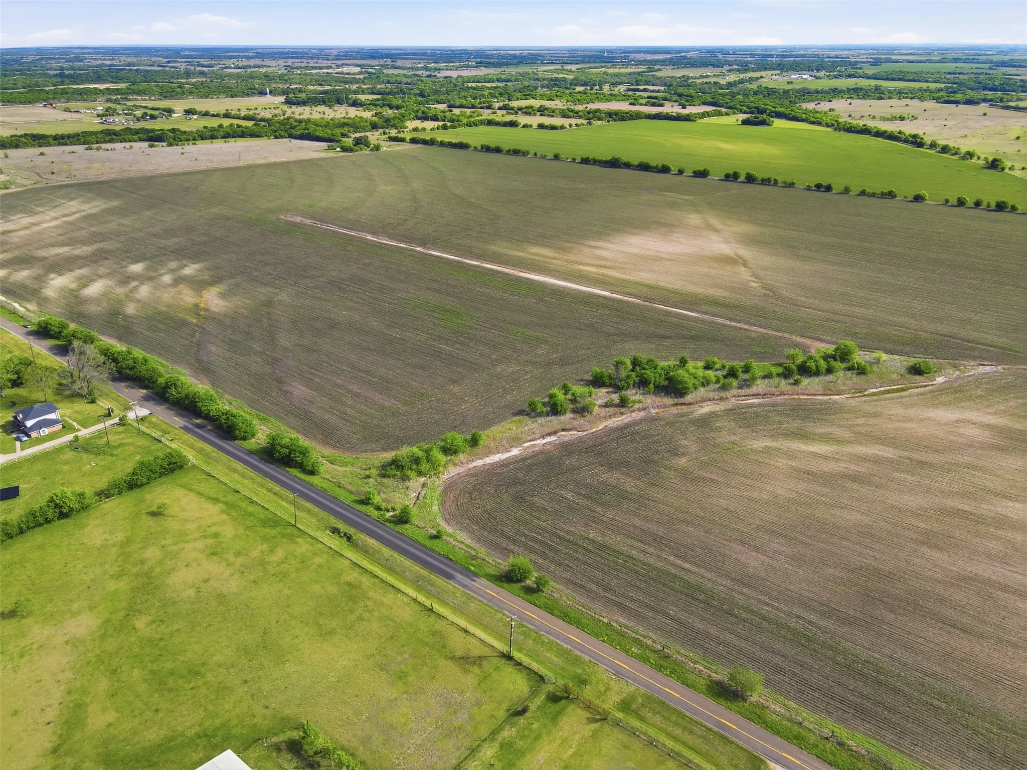 Aerial view of sparsely populated area featuring rows of crops