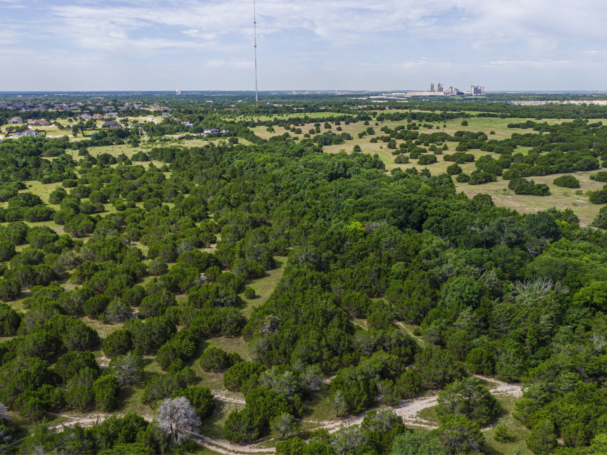 Aerial view of property and surrounding area featuring a heavily wooded area