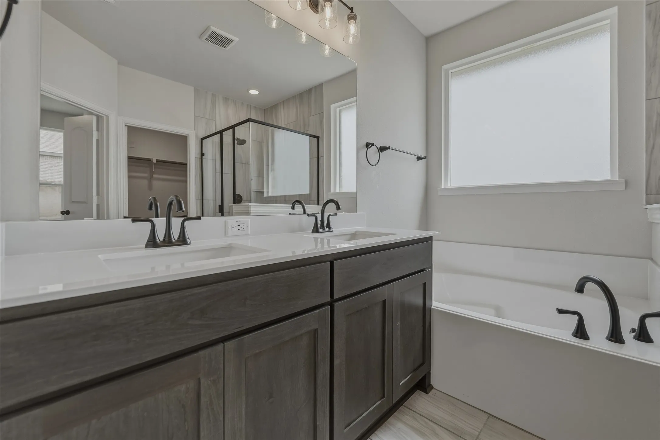 Dual vanity with integrated sinks, white countertops, and dark wood-finish cabinetry