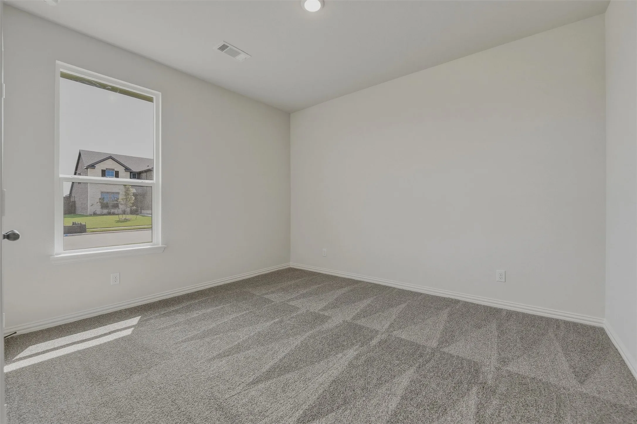 Neutral wall paint, patterned carpeting, and recessed ceiling lighting