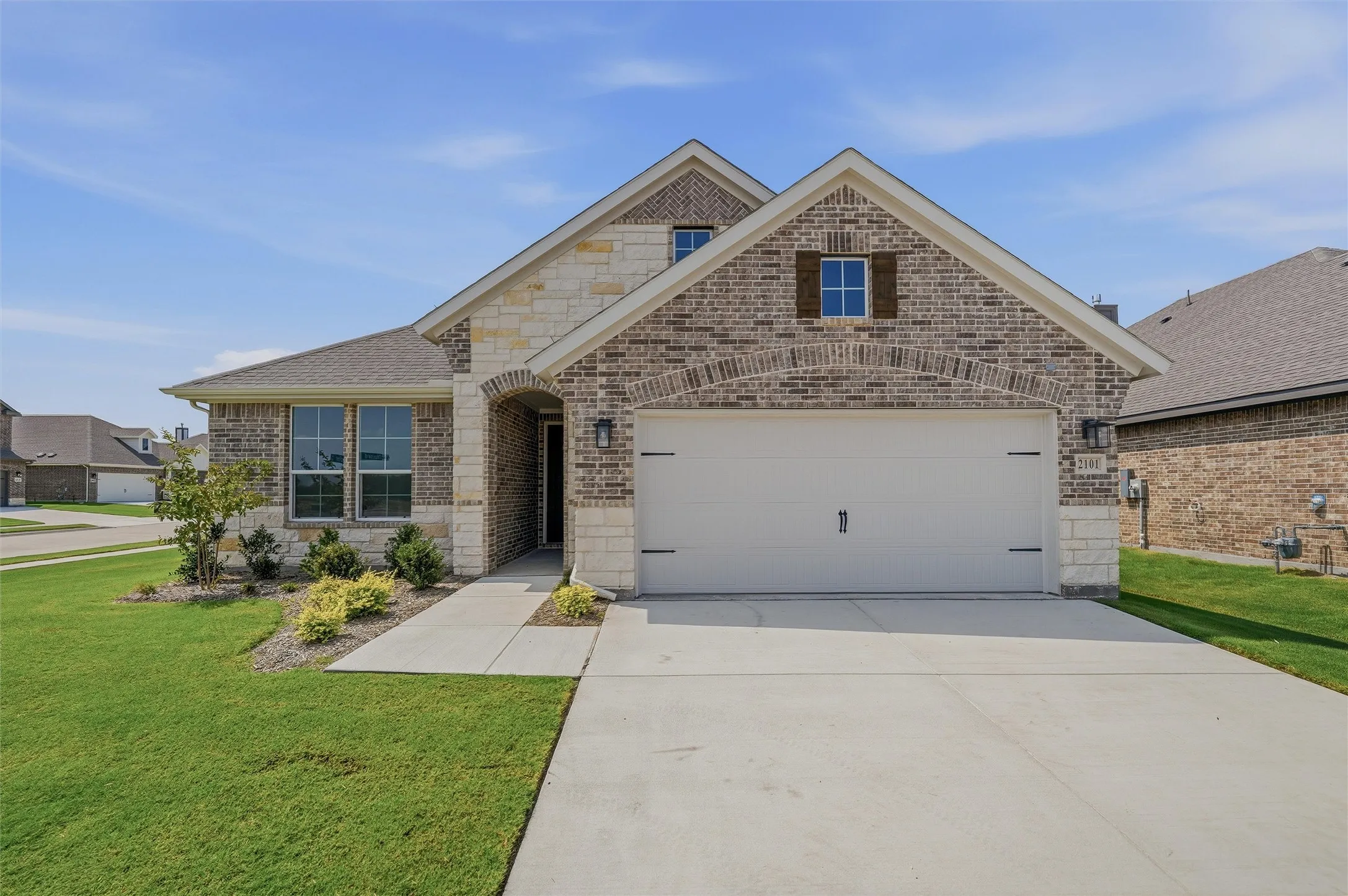 Charming brick exterior with arched gable detailing and blue shutters