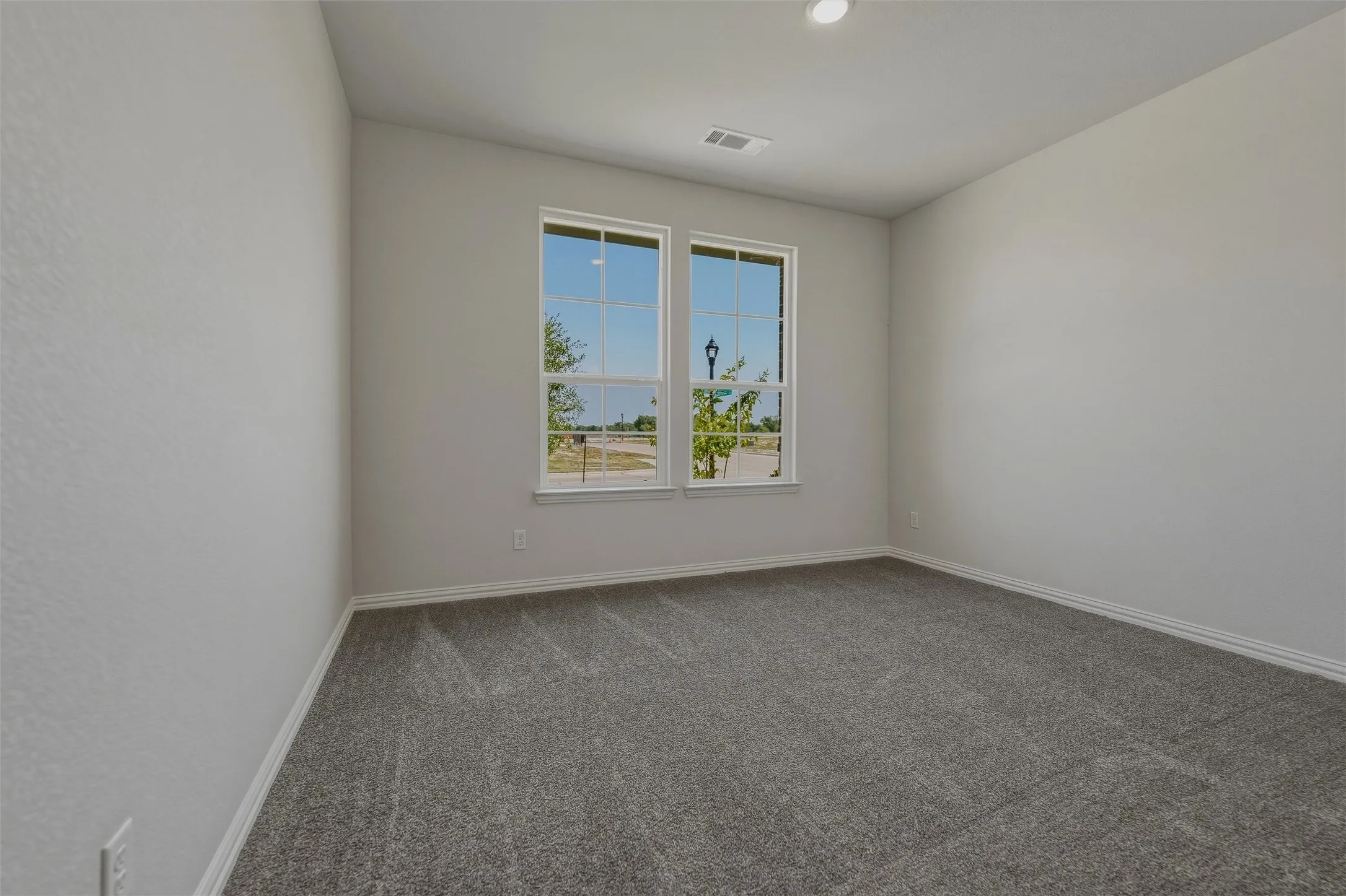 Dual windows, recessed lighting, and textured walls