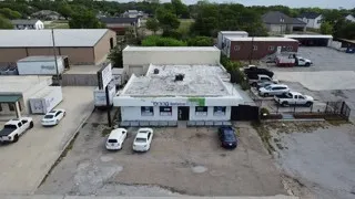 The property features a single-story building with a flat roof and a paved parking area