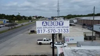 This commercial property features a large sign for "ABBY USED APPLIANCES AND REPAIR" with a contact number