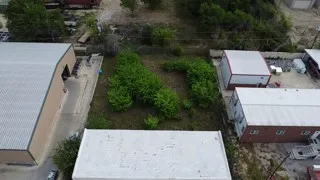 Aerial view of the property with surrounding structures and vegetation