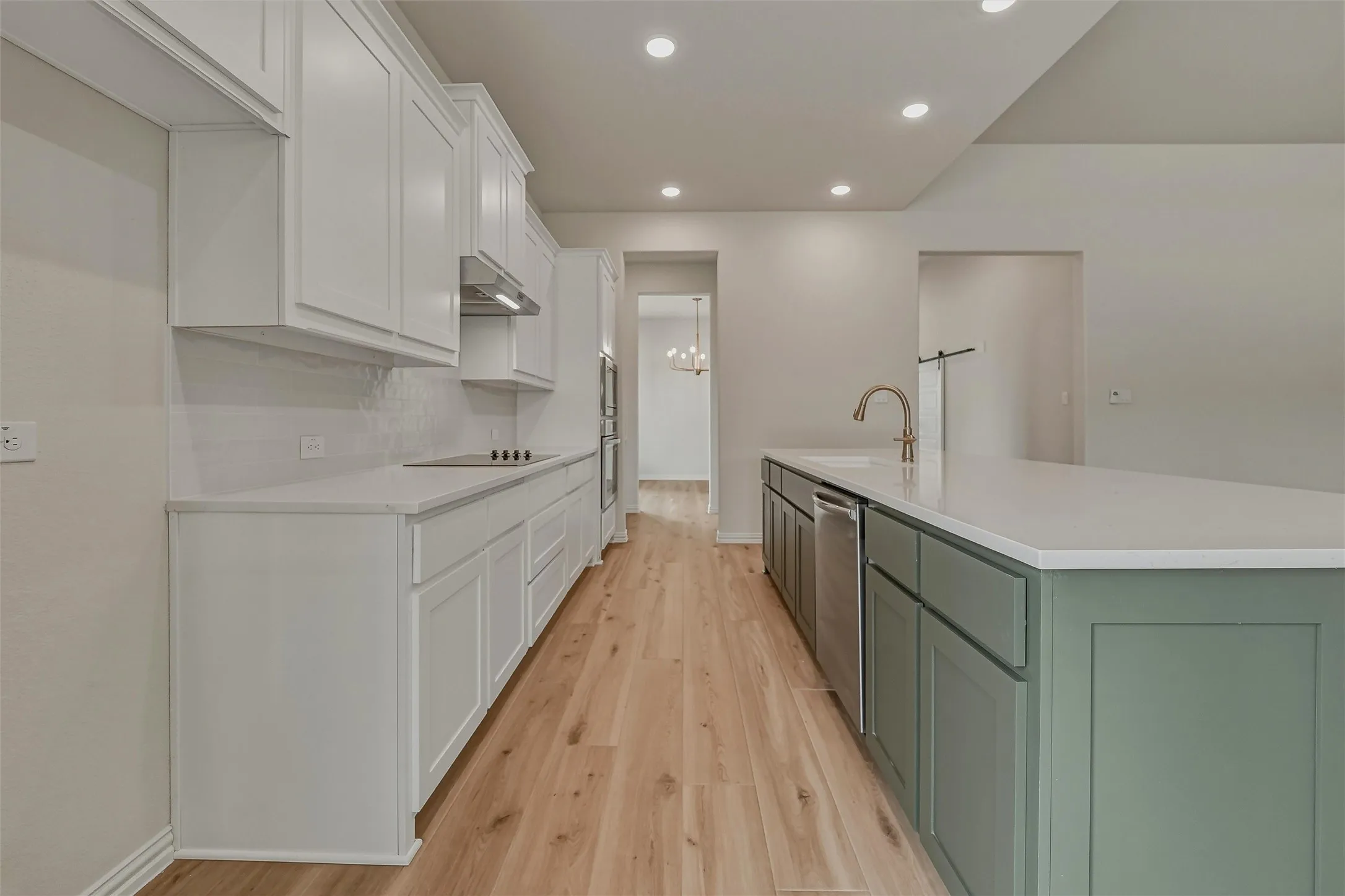 Kitchen featuring a large island with a surface-mounted sink, a stainless steel dishwasher, and two-tone cabinetry