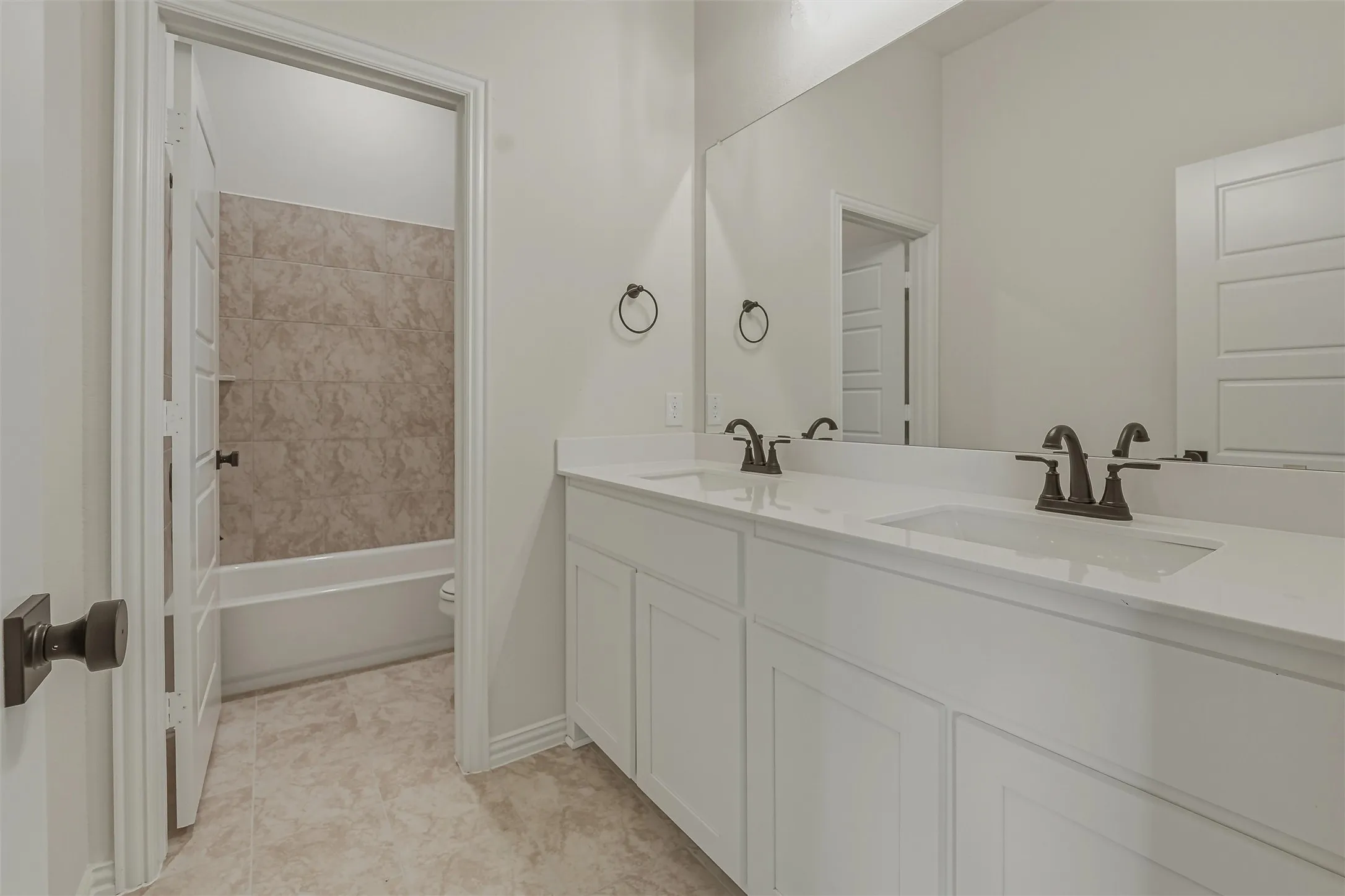Dual sink vanity with white cabinetry and integrated countertops