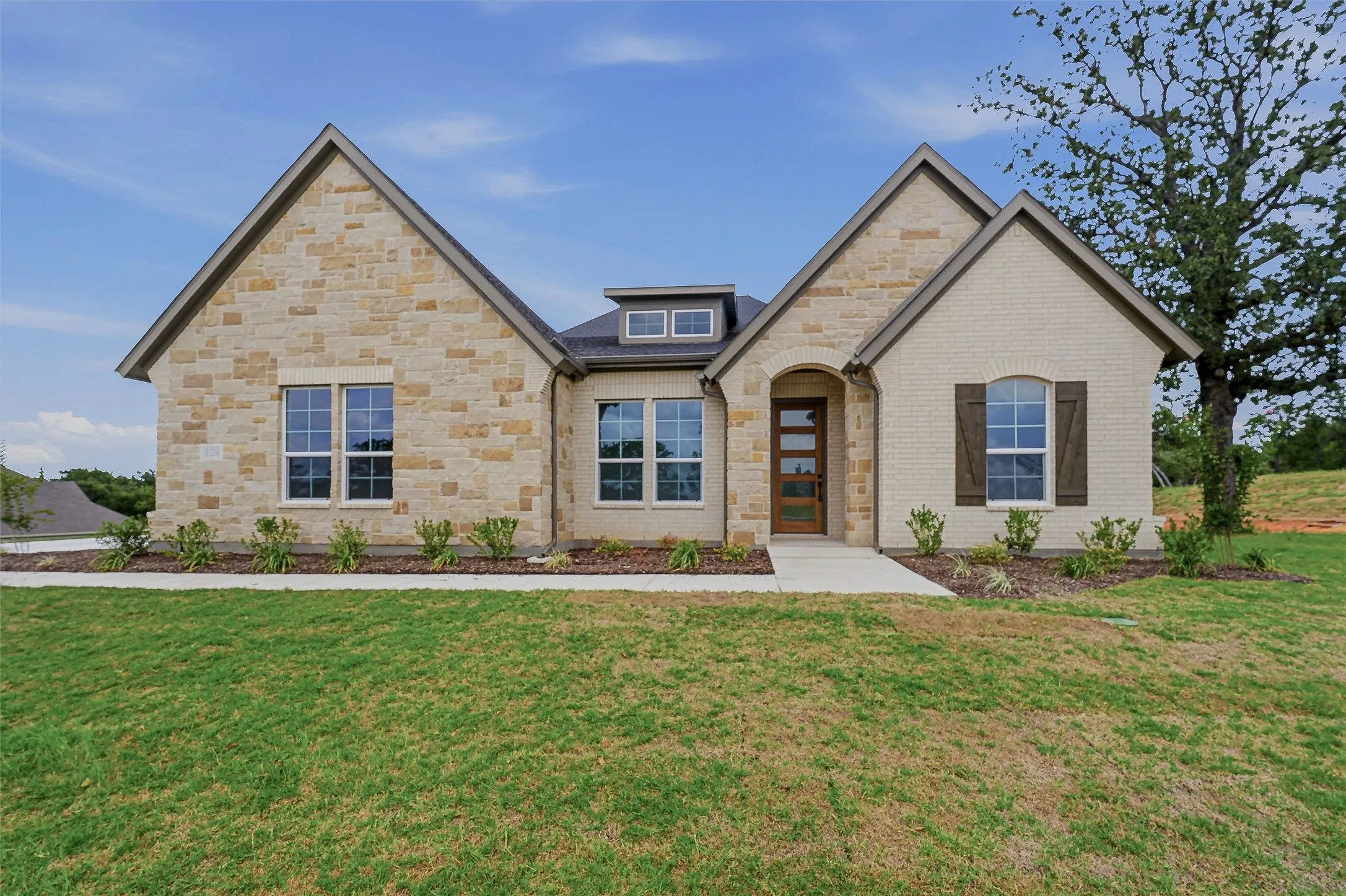 Stone and brick exterior featuring multiple gables and a dormer