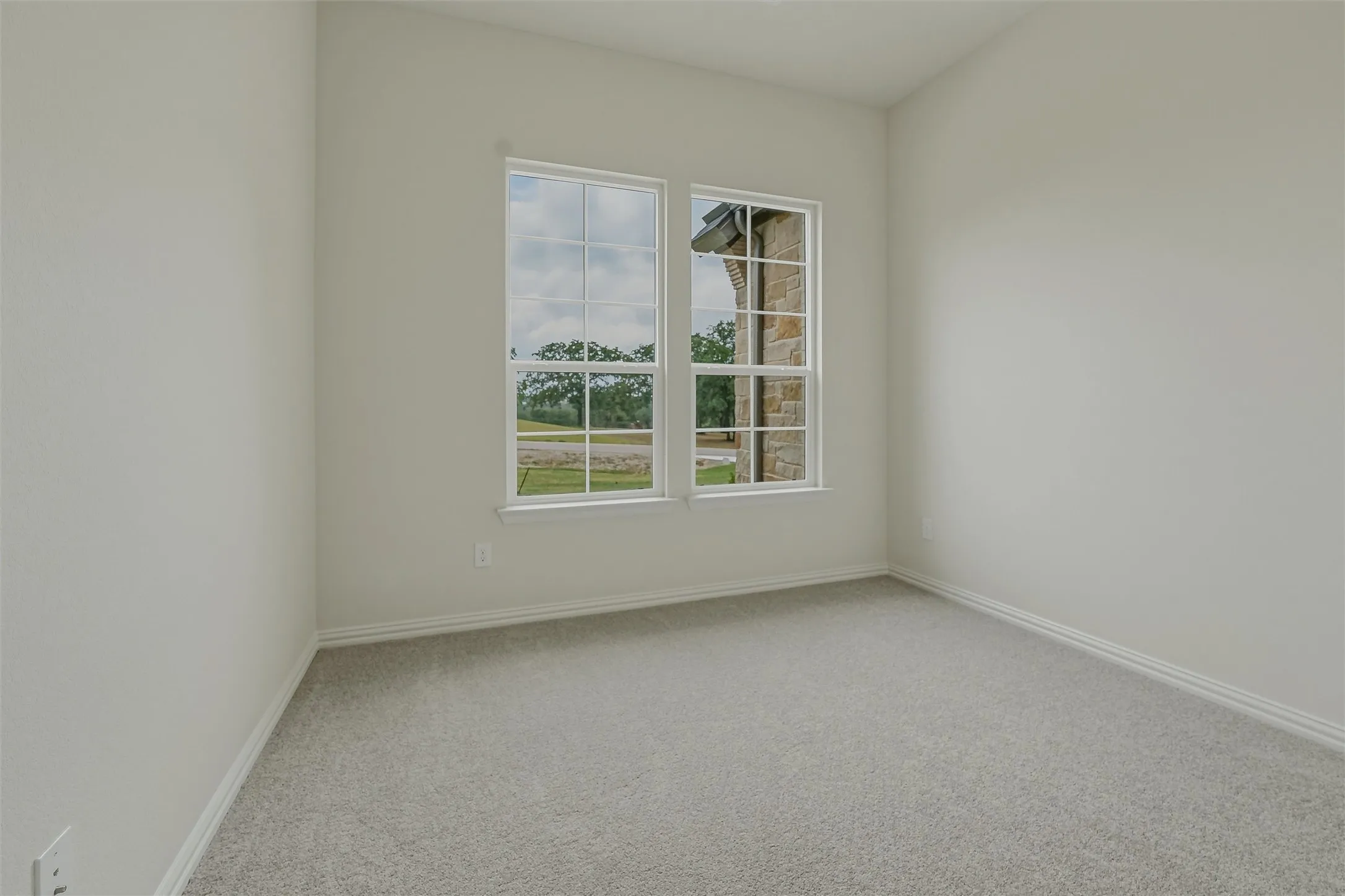 Room featuring light gray carpeting, neutral wall color, and white trim
