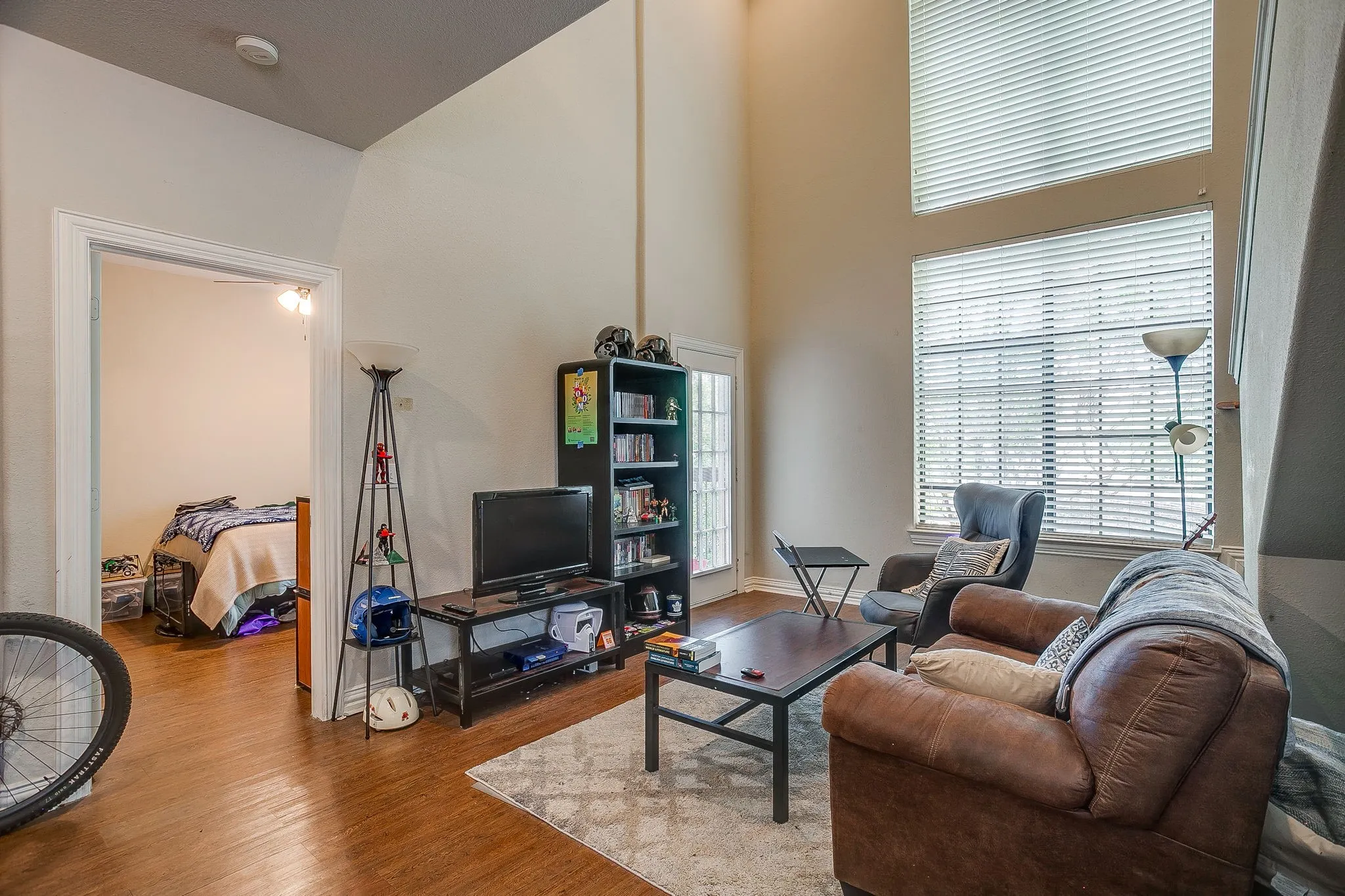 Living area with wood finished floors and a high ceiling