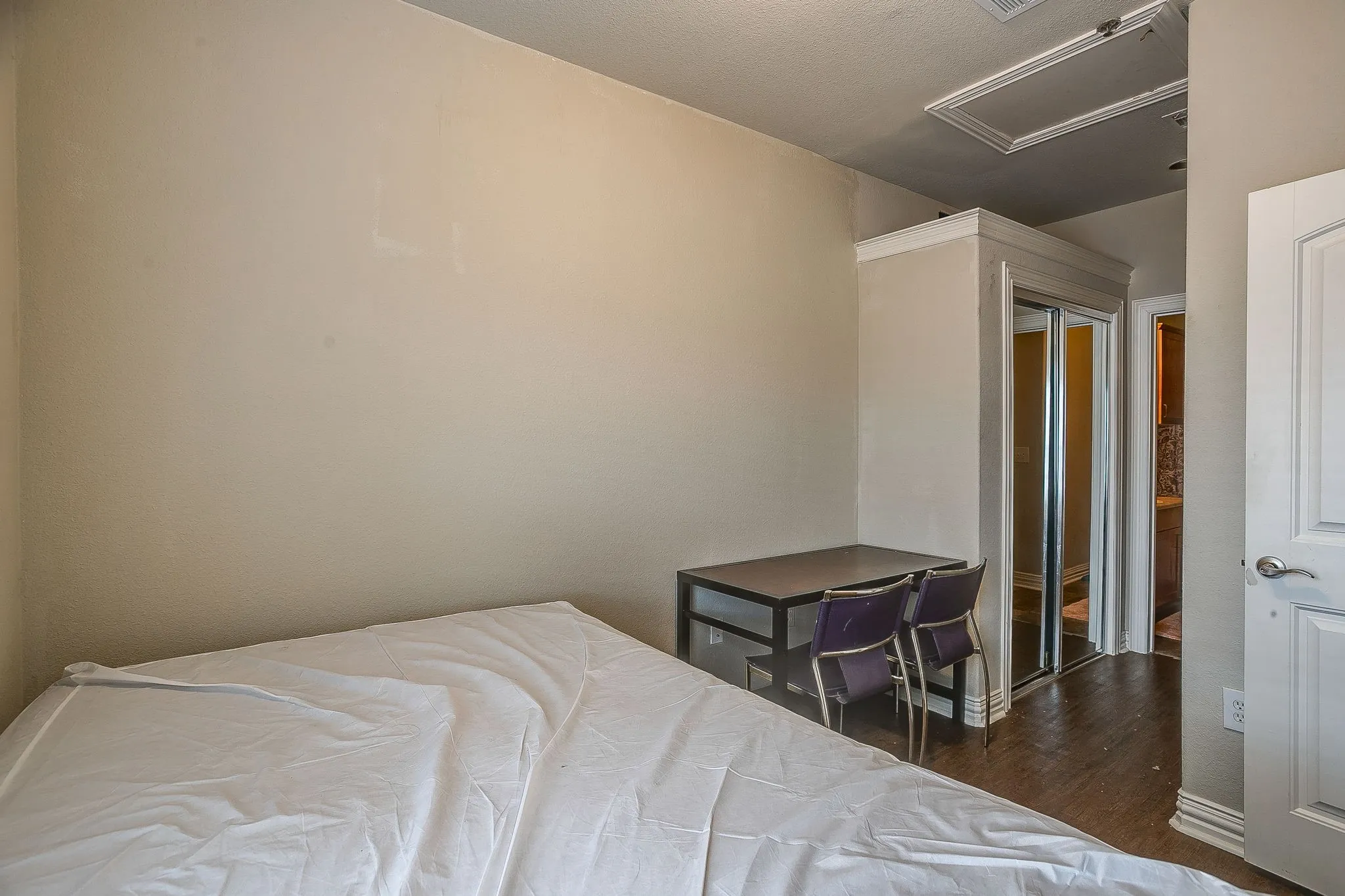 Bedroom with dark wood-style floors and a closet