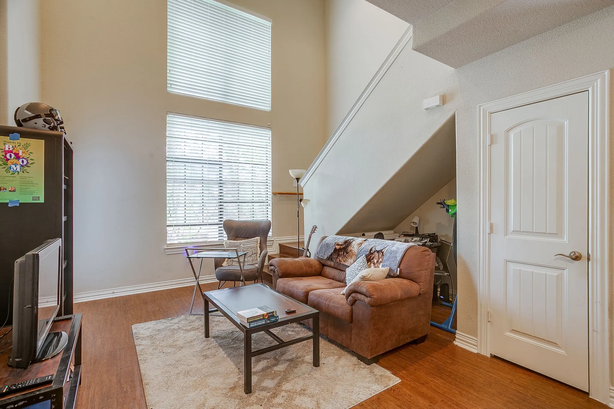 Living room featuring light wood-style flooring and a high ceiling
