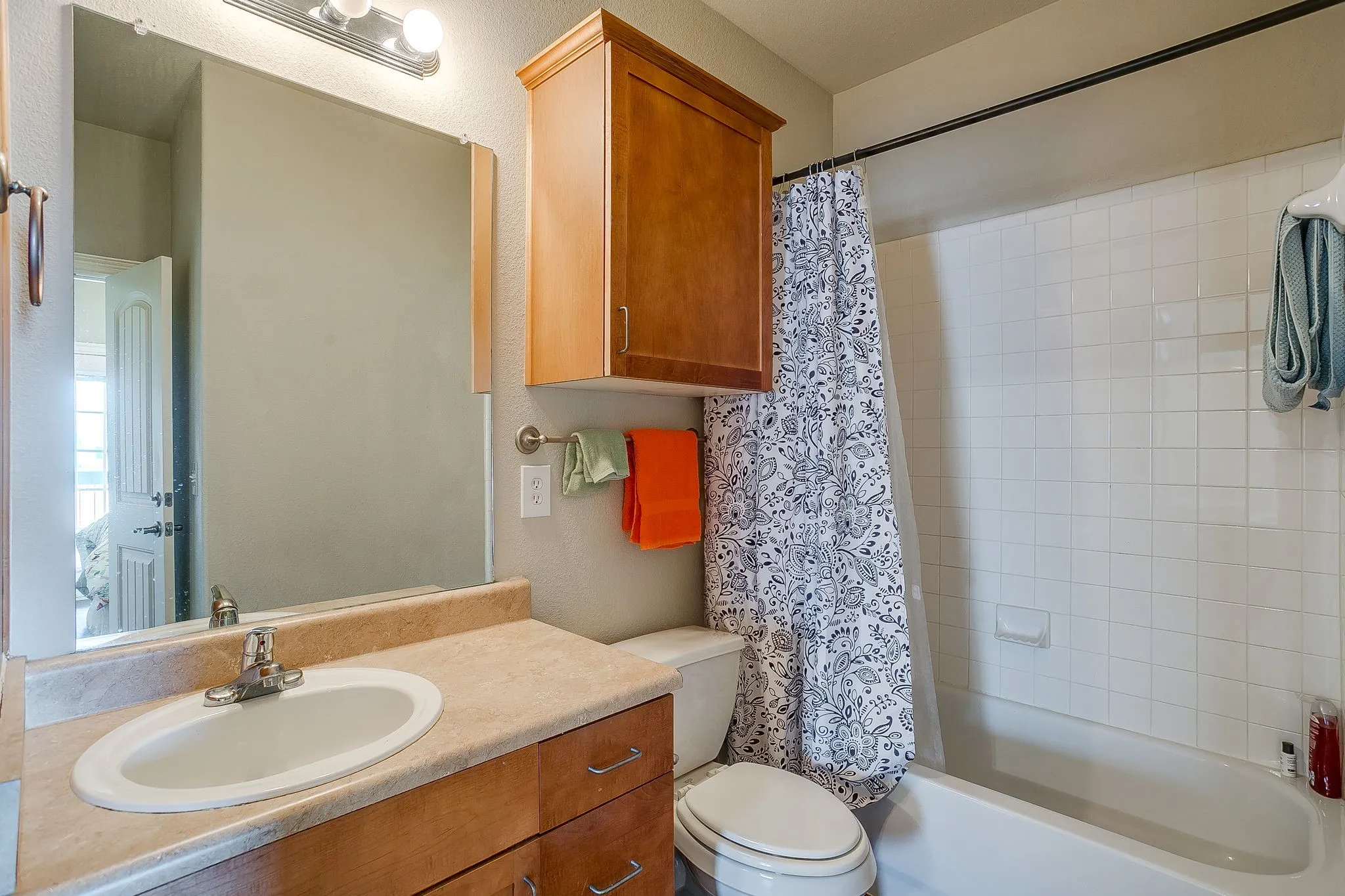 Bathroom featuring vanity and shower / bath combination with curtain