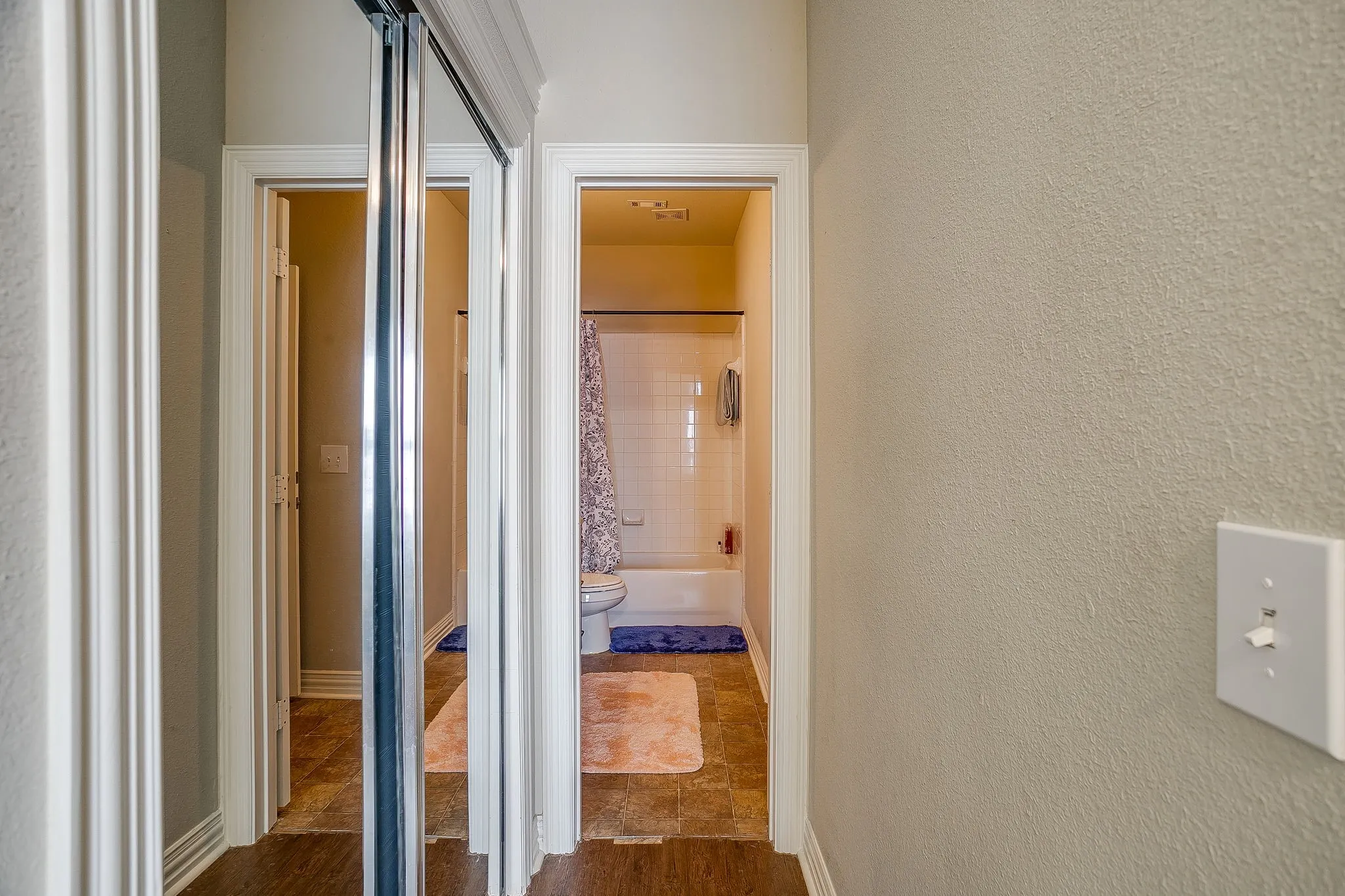 Hall with a textured wall and baseboards