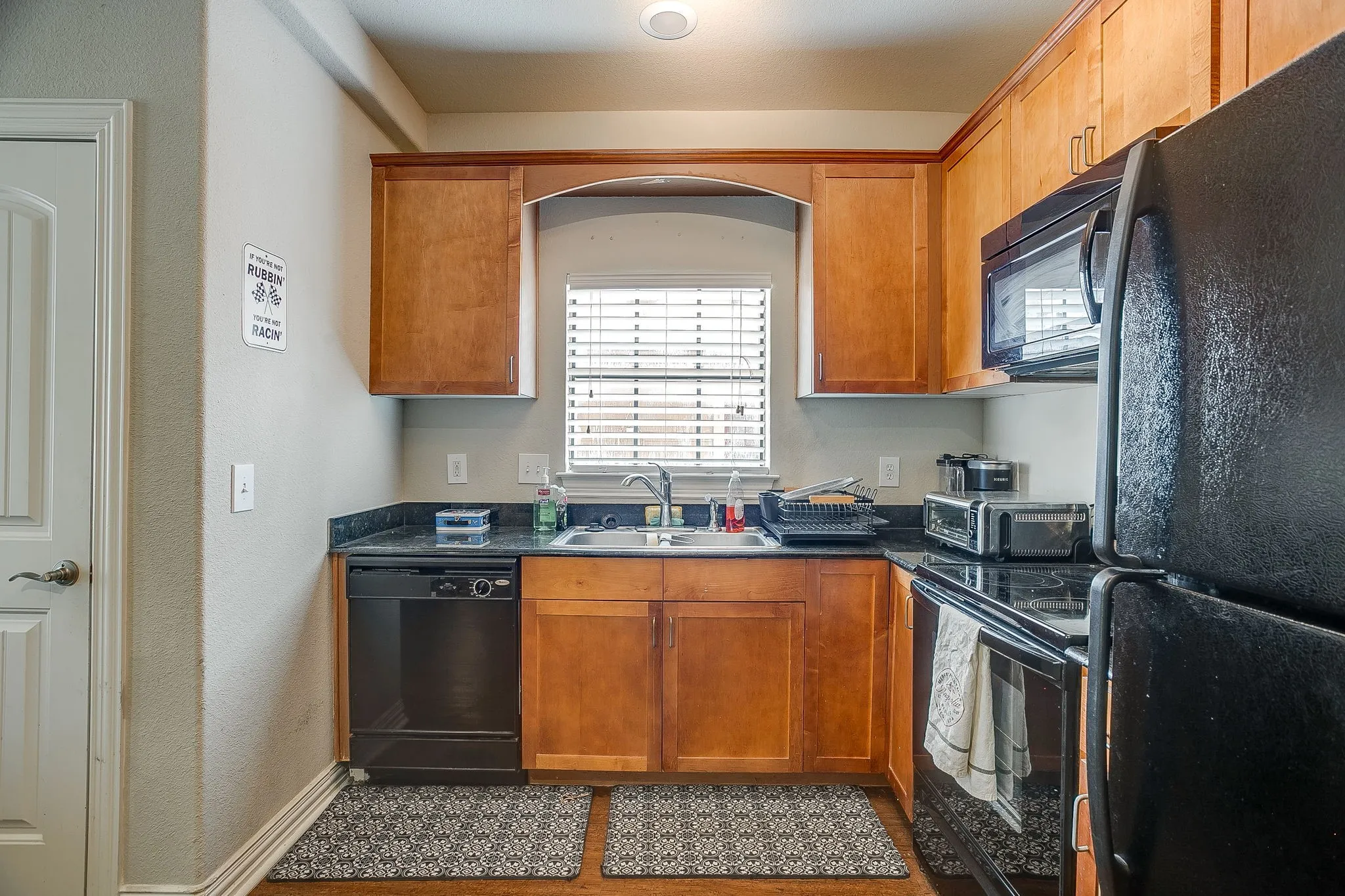 Kitchen with black appliances and wood finish cabinetry