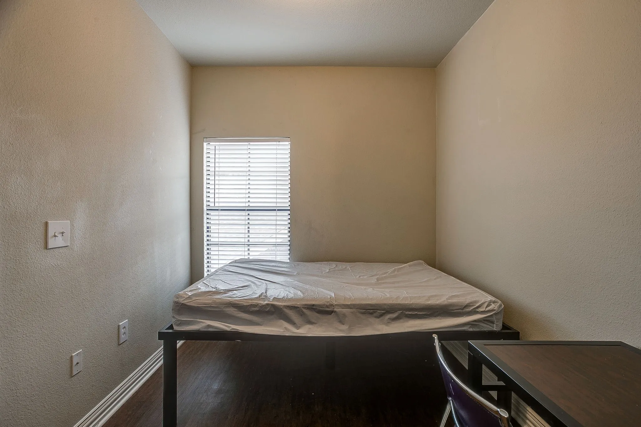 Bedroom featuring a textured wall and wood finished floors