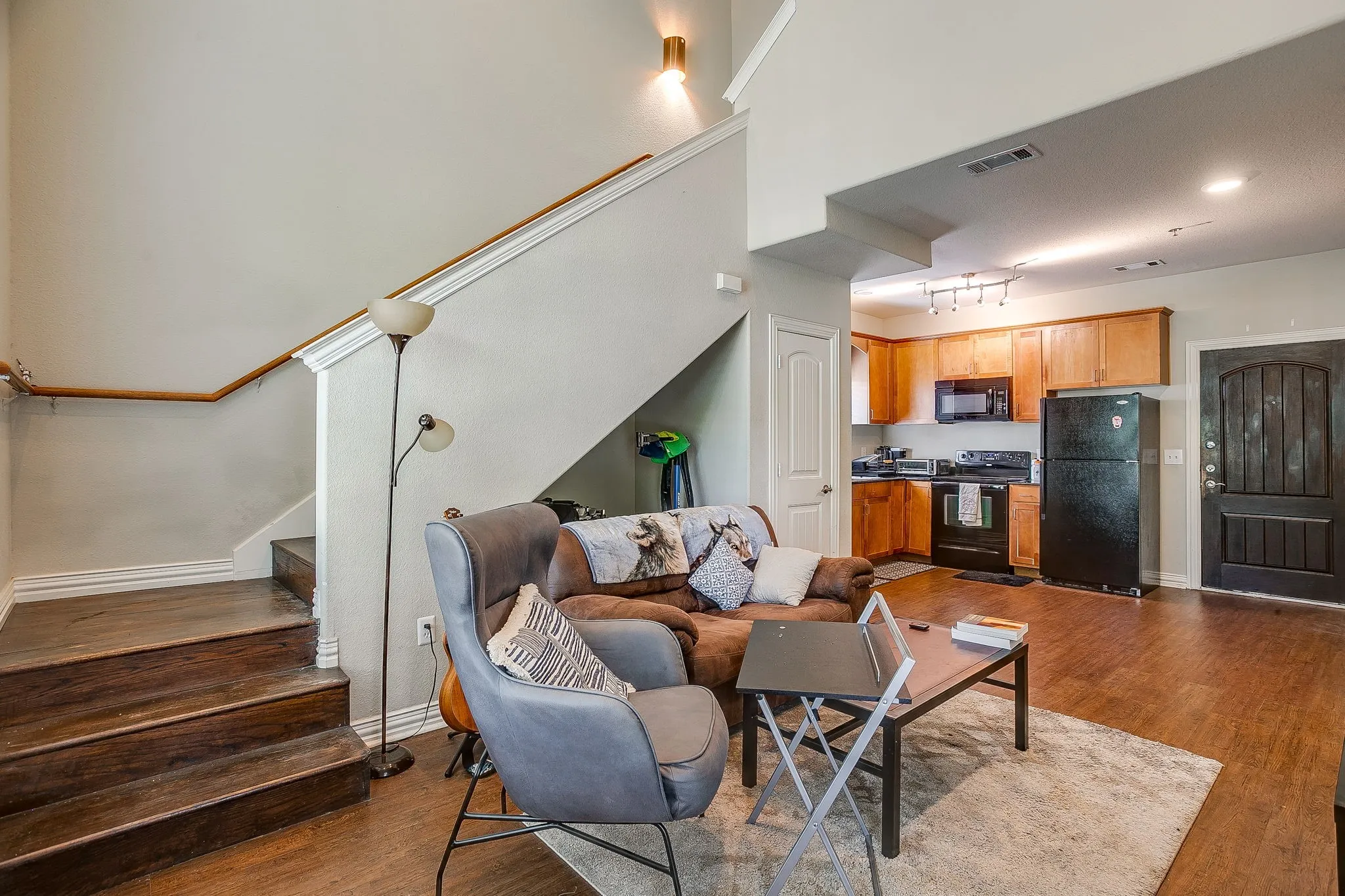 Living room with stairway and dark wood-style floors