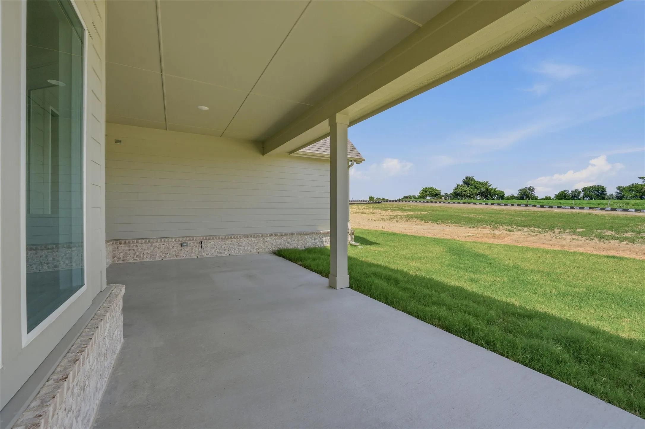 Covered outdoor patio with concrete flooring