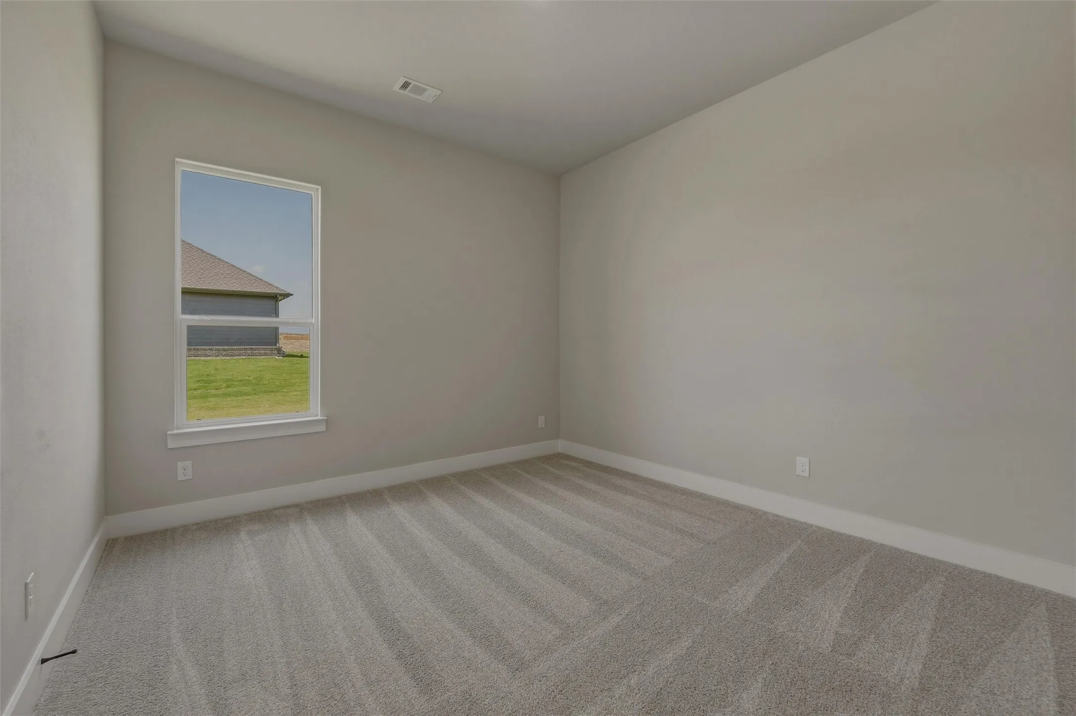 Neutral-toned walls complement the light-colored patterned carpet