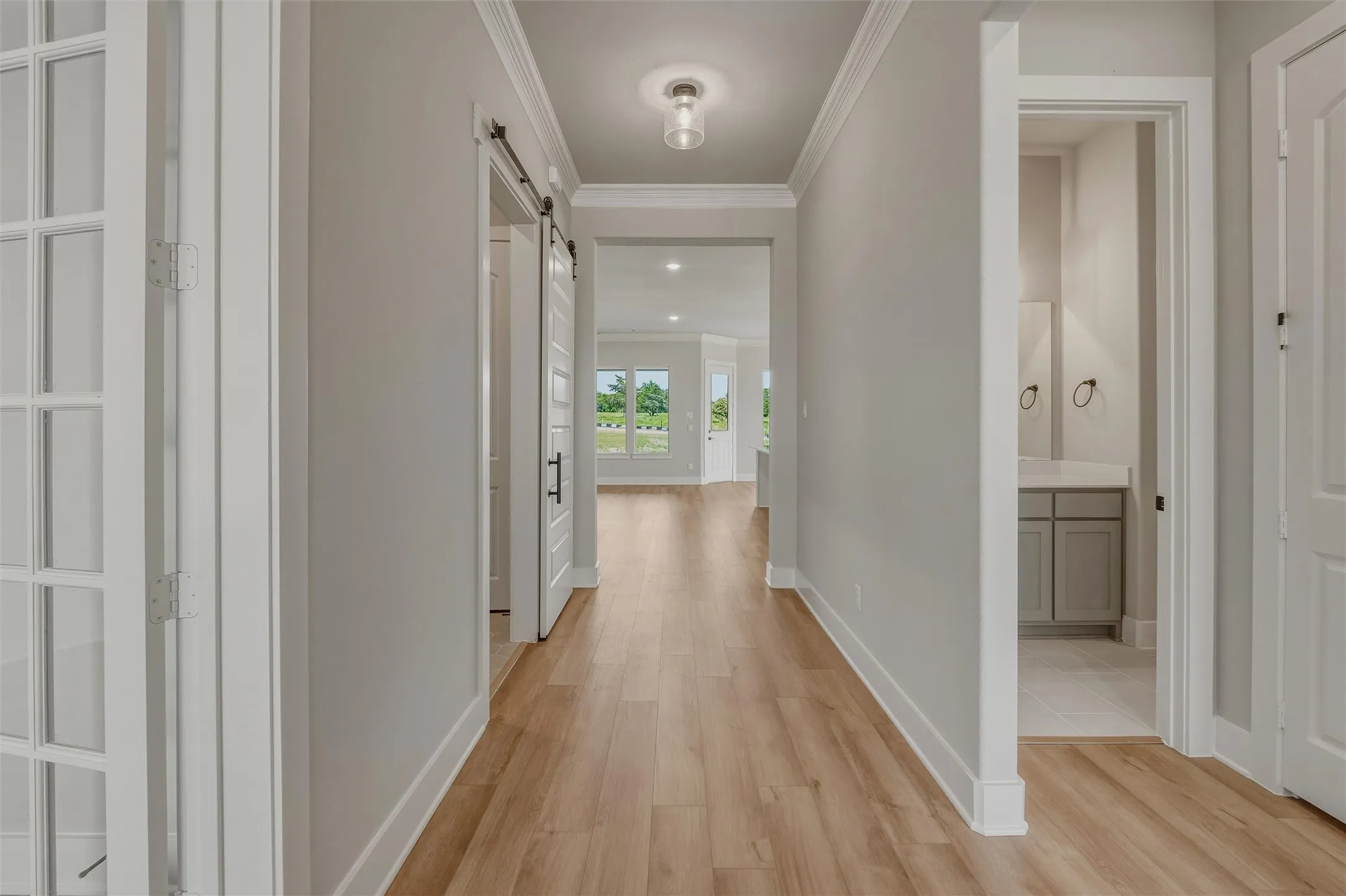 Hallway featuring wood-finish flooring and crown molding