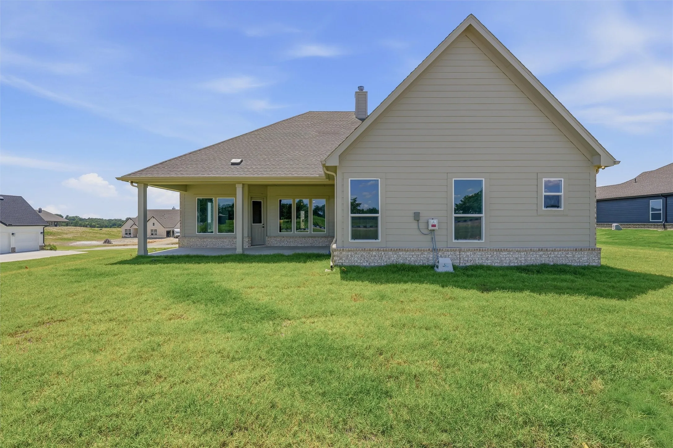 Expansive rear lawn with a covered patio