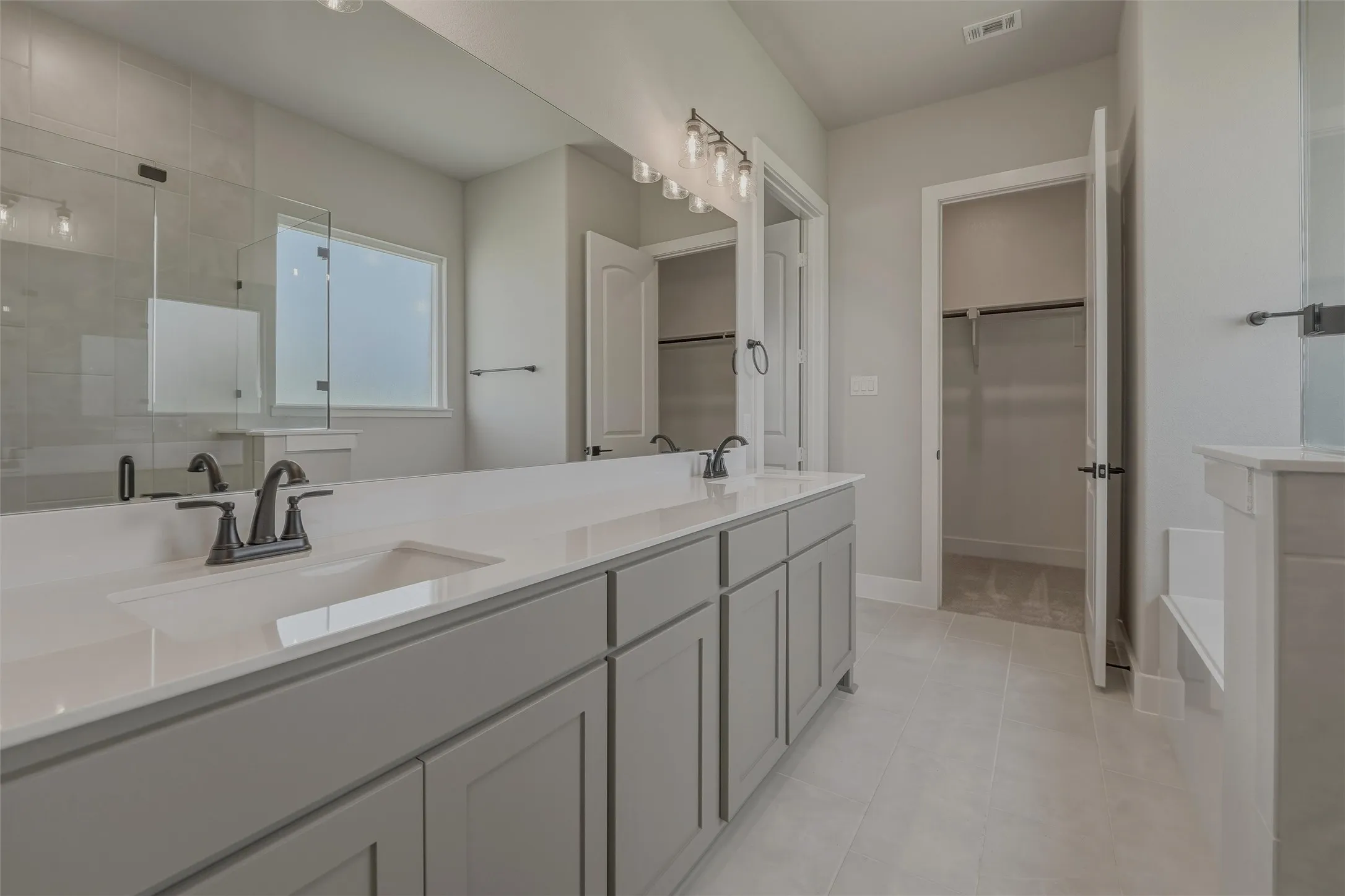 Double vanity featuring a light-toned countertop and dual integrated sinks with matte black fixtures