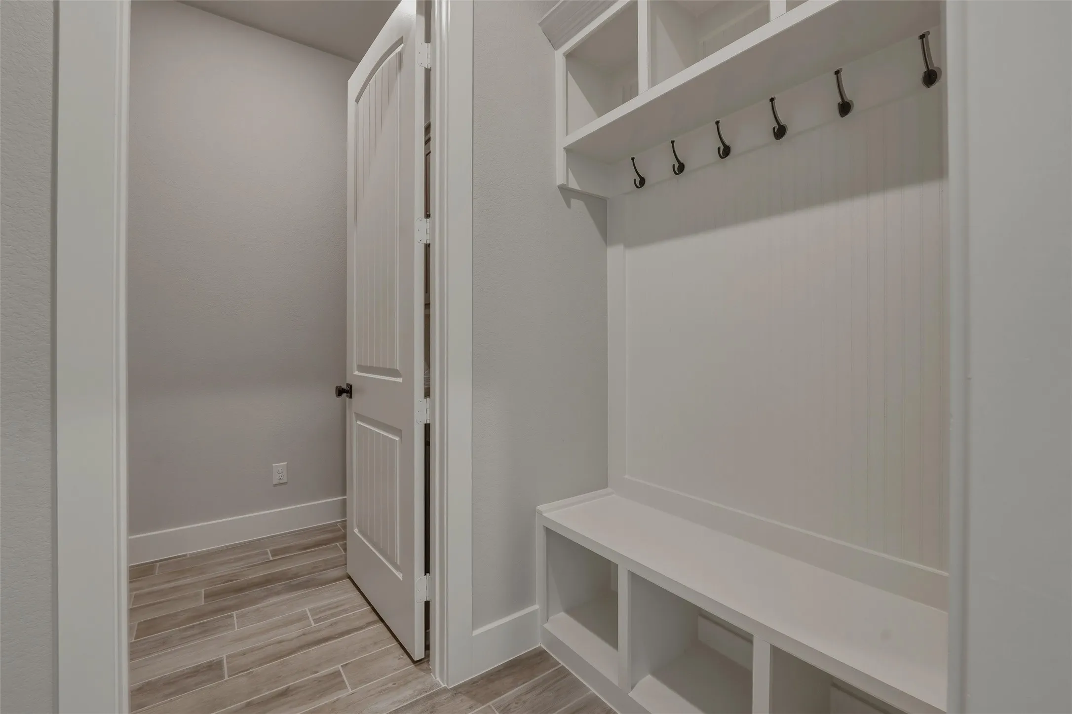 Built-in mudroom bench with cubby storage and upper shelving