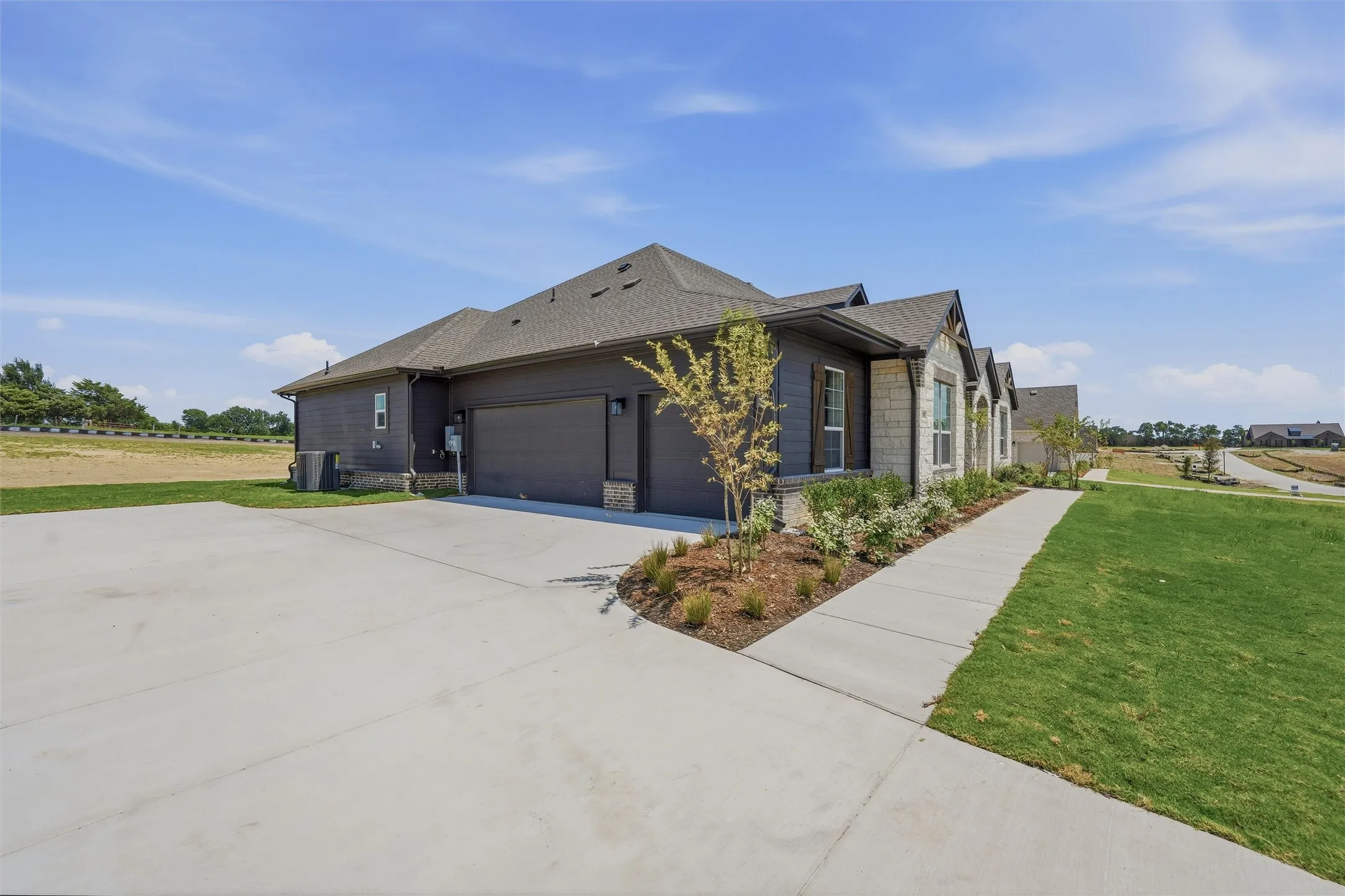 Contemporary home exterior featuring a dark gray siding and stone facade