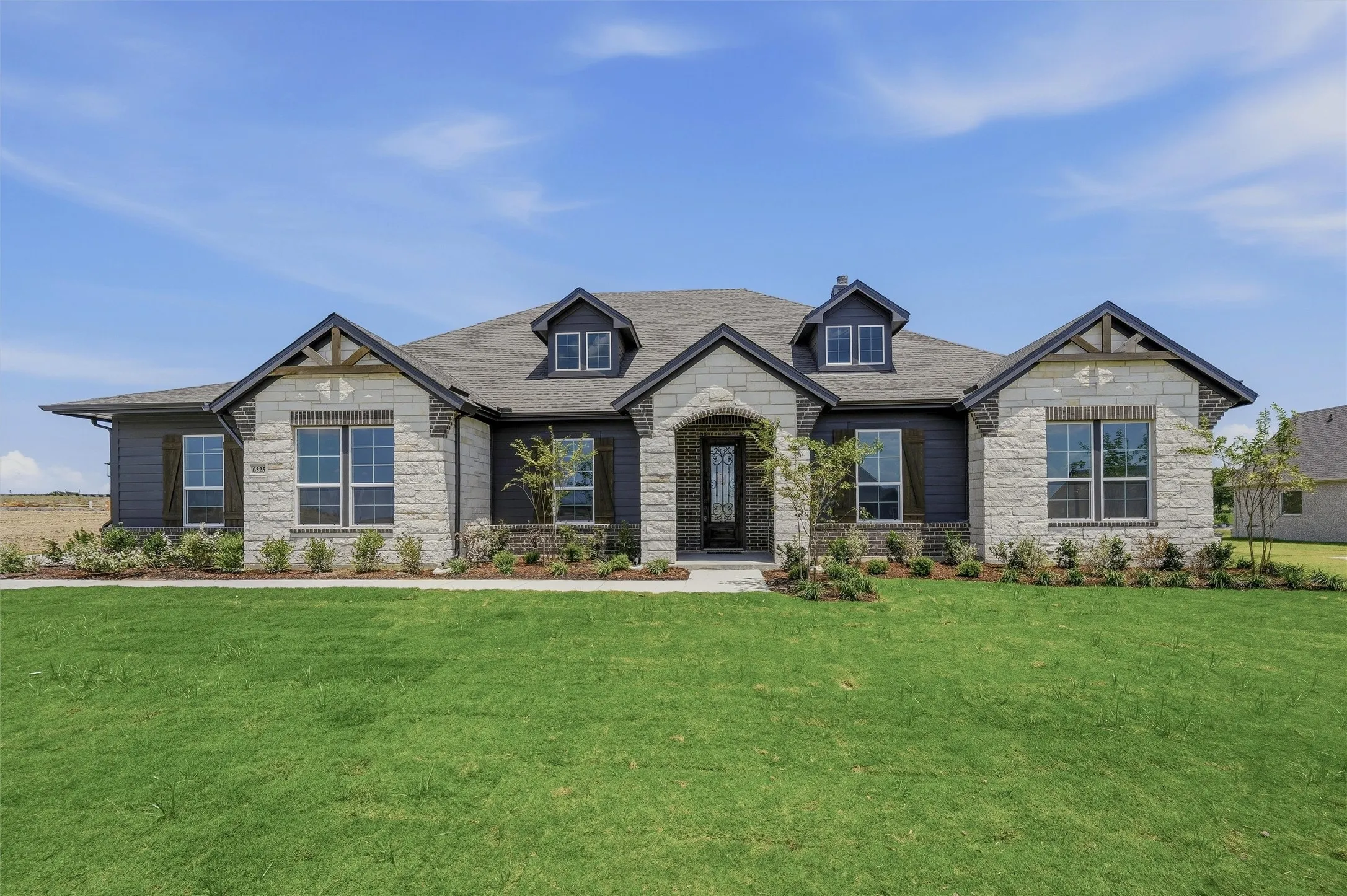 Stone and siding exterior with dark trim accents