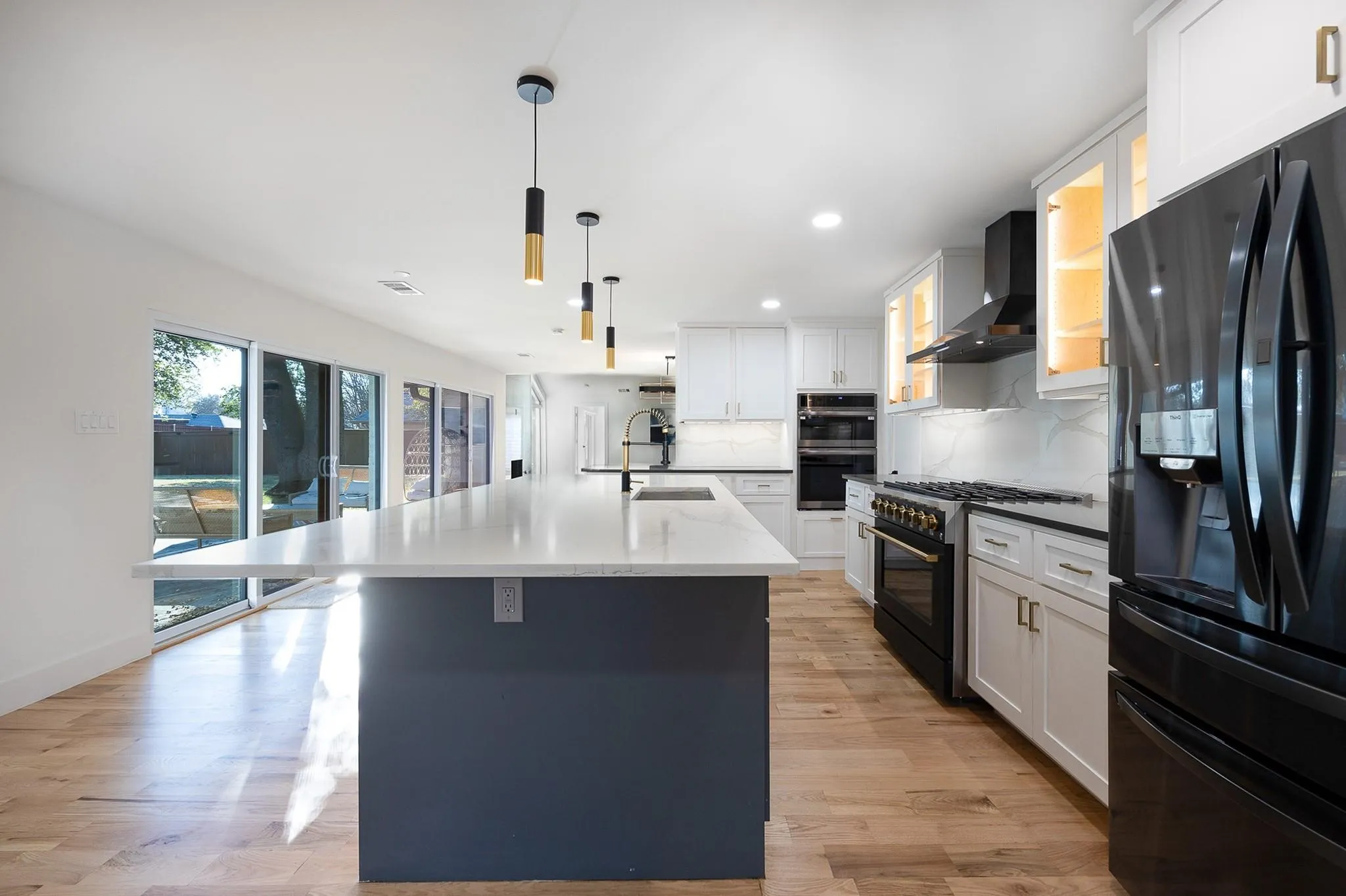 Kitchen opens through glass to the pool patio