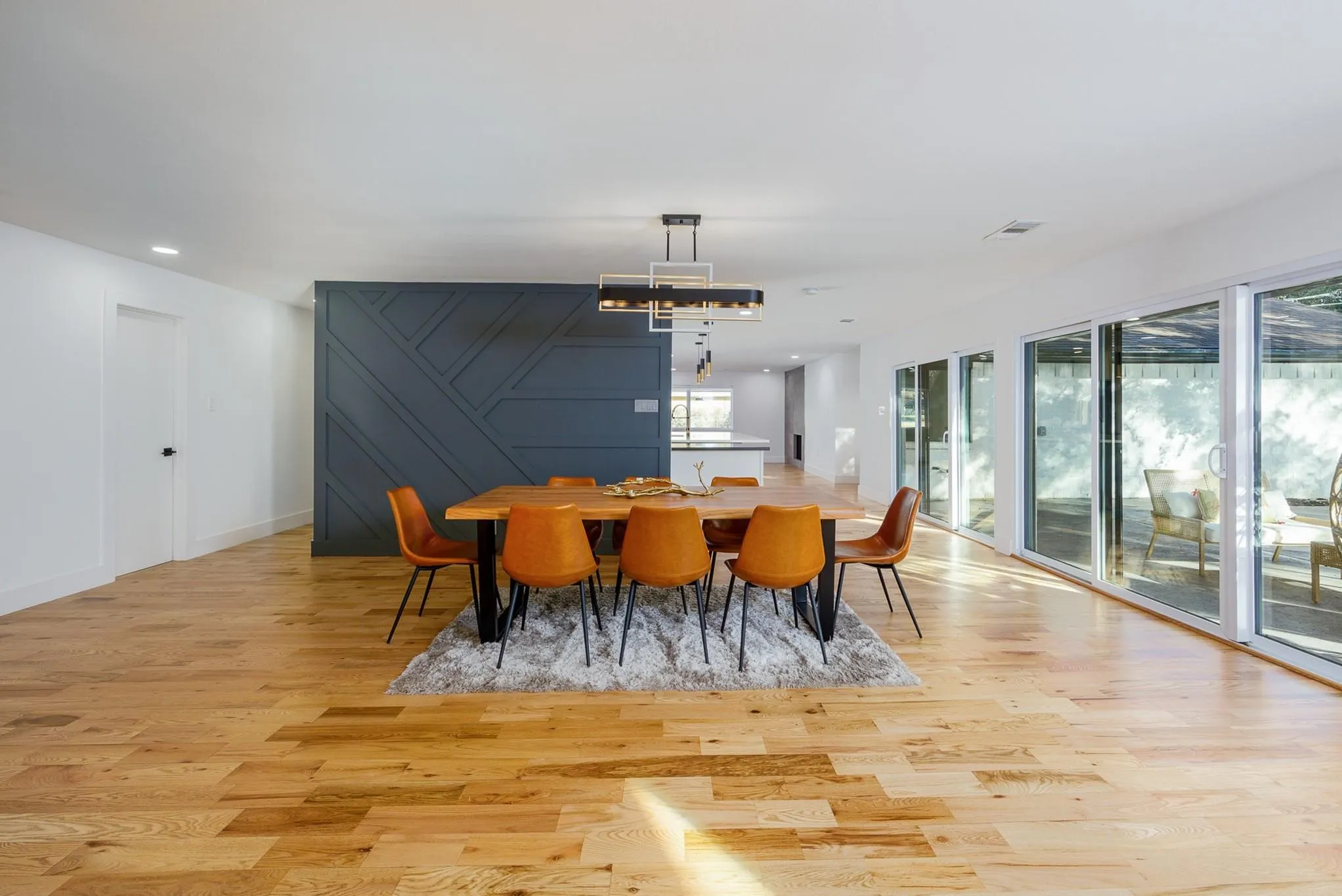 Sunlit dining beneath statement lighting