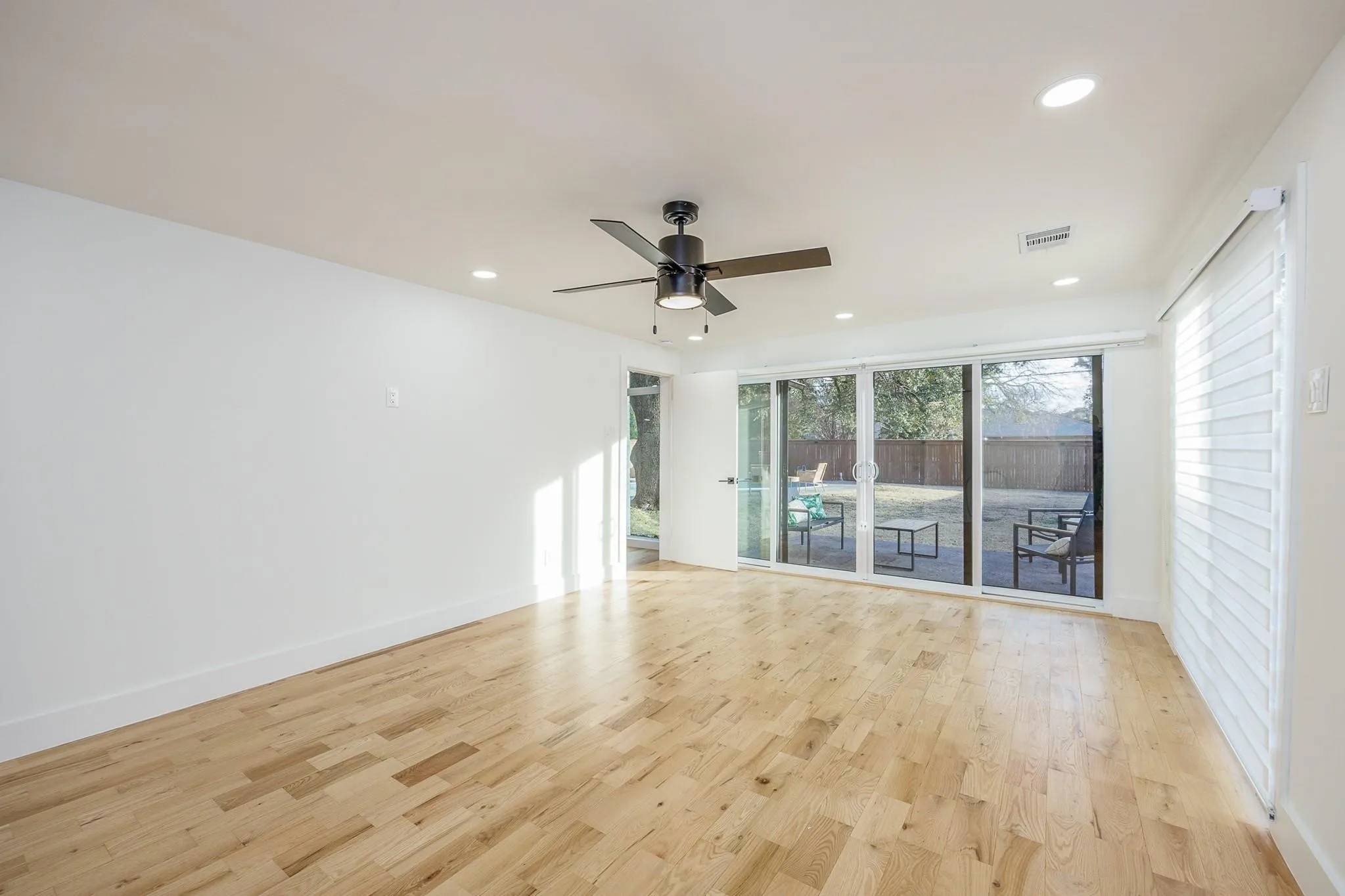 Sun-drenched flex room opens through sliders to the yard