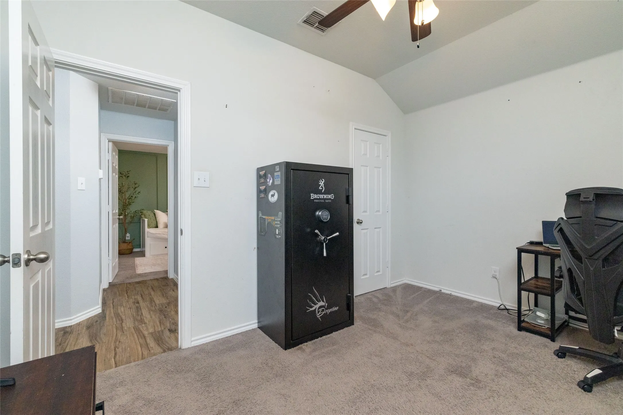 Office area with lofted ceiling, a ceiling fan, and light colored carpet