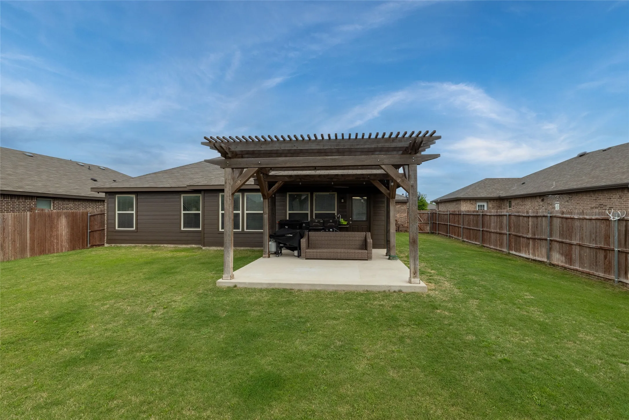 Rear view of property with a patio area, a pergola, and a fenced backyard