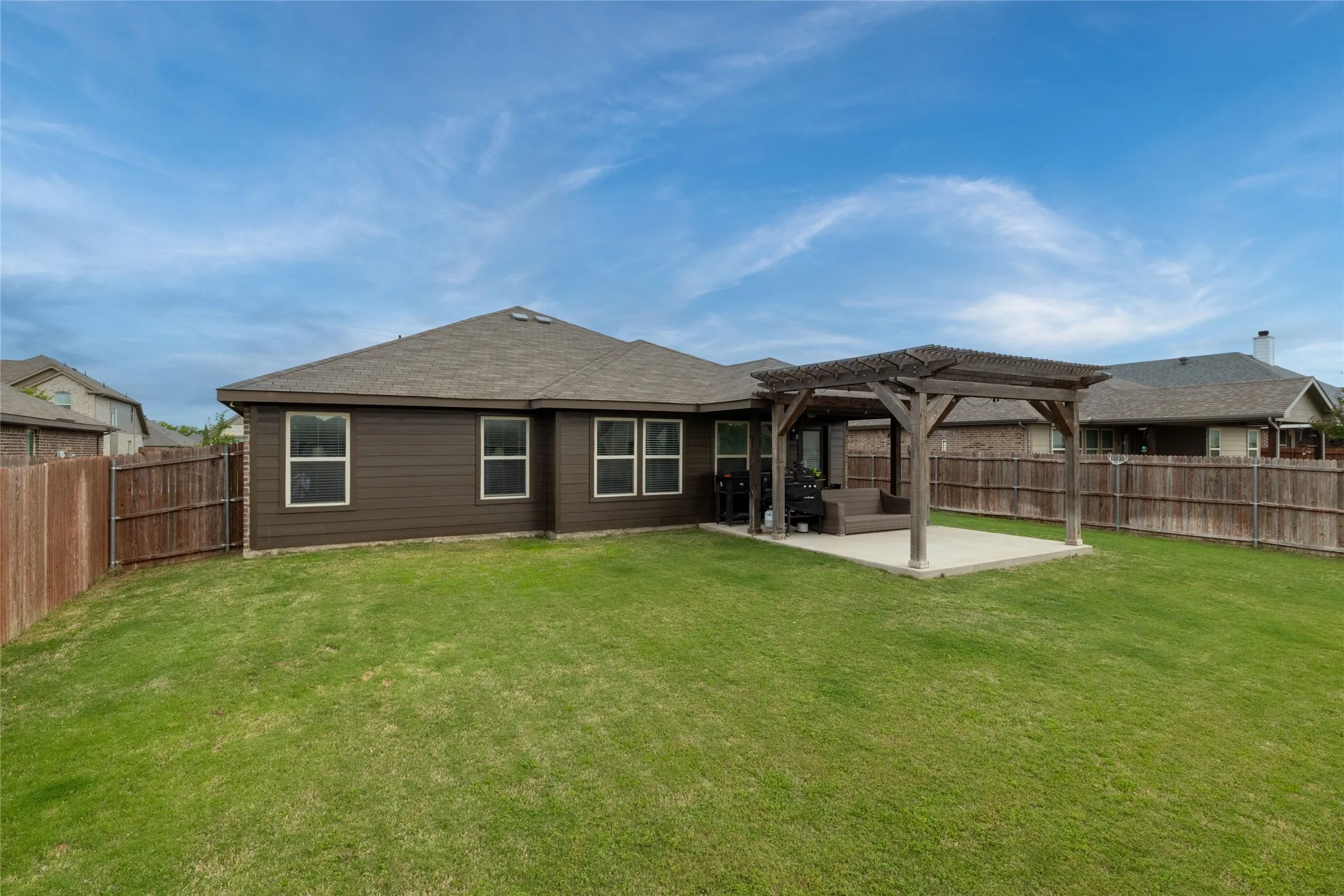 Rear view of property with a patio area, a pergola, a fenced backyard, and a shingled roof