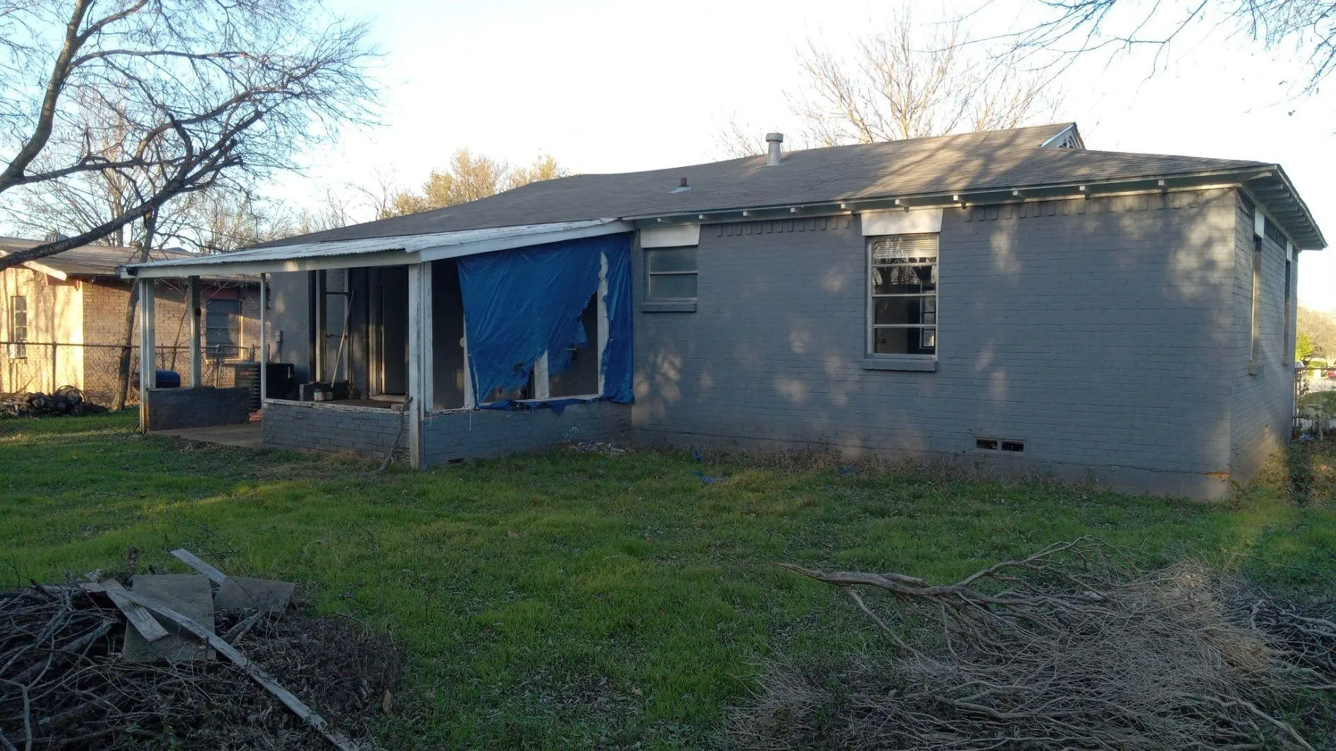 Rear view of property with a yard, brick siding, and a patio area
