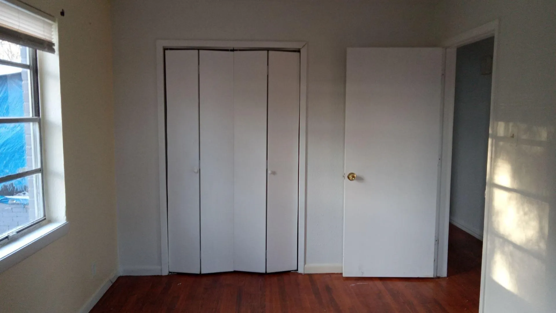 Unfurnished bedroom featuring dark wood-style flooring and a closet
